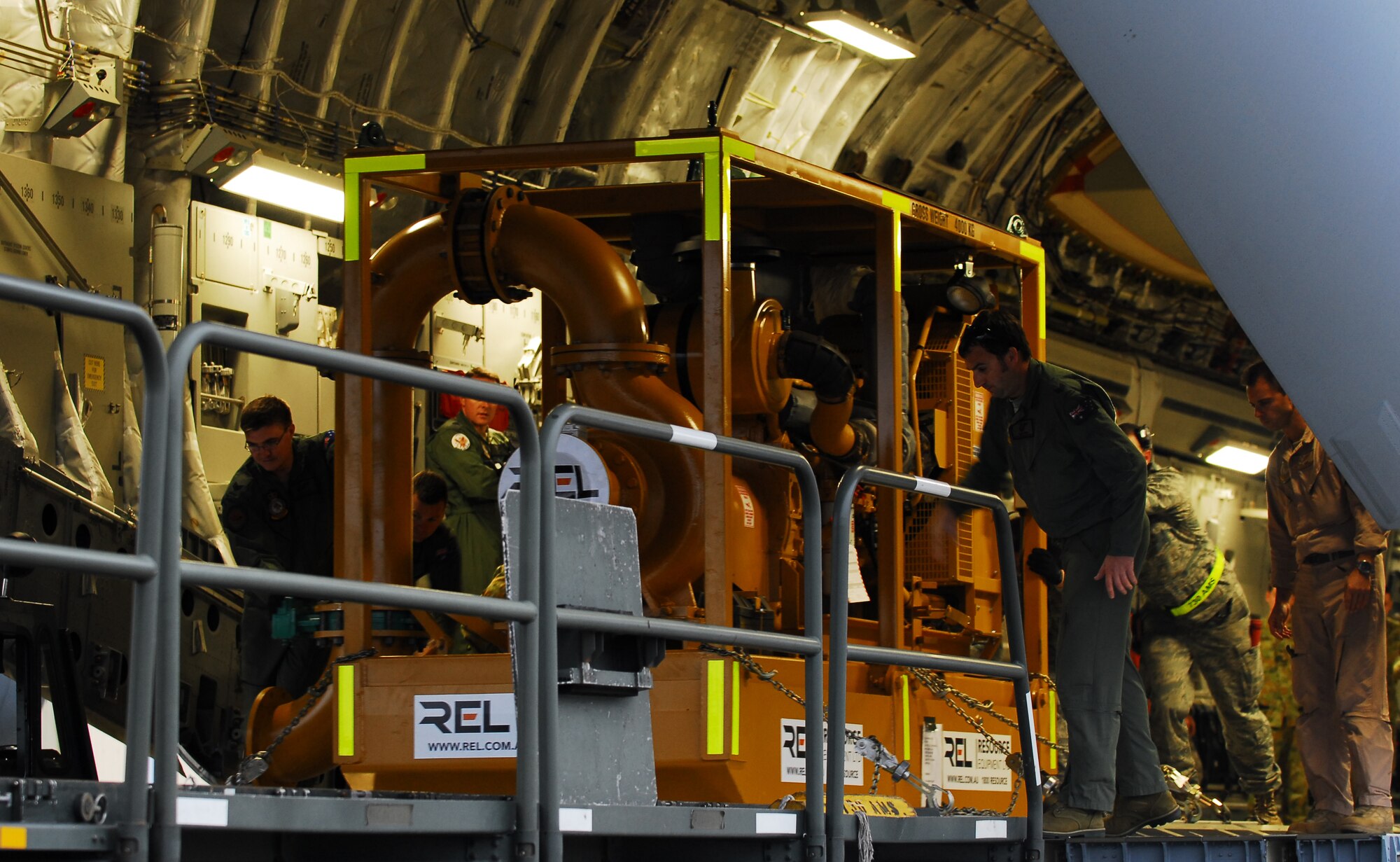 YOKOTA AIR BASE, Japan -- Personnel from the 730th Air Mobility Squadron and members from a Royal Australian Air Force C-17 Globemaster III off load a water cannon system here March 22. The system is a series of pumps and trailers tha can be remotely maneuvered into a location. (U.S. Air Force photo/Staff Sgt. Robin Stanchak)
