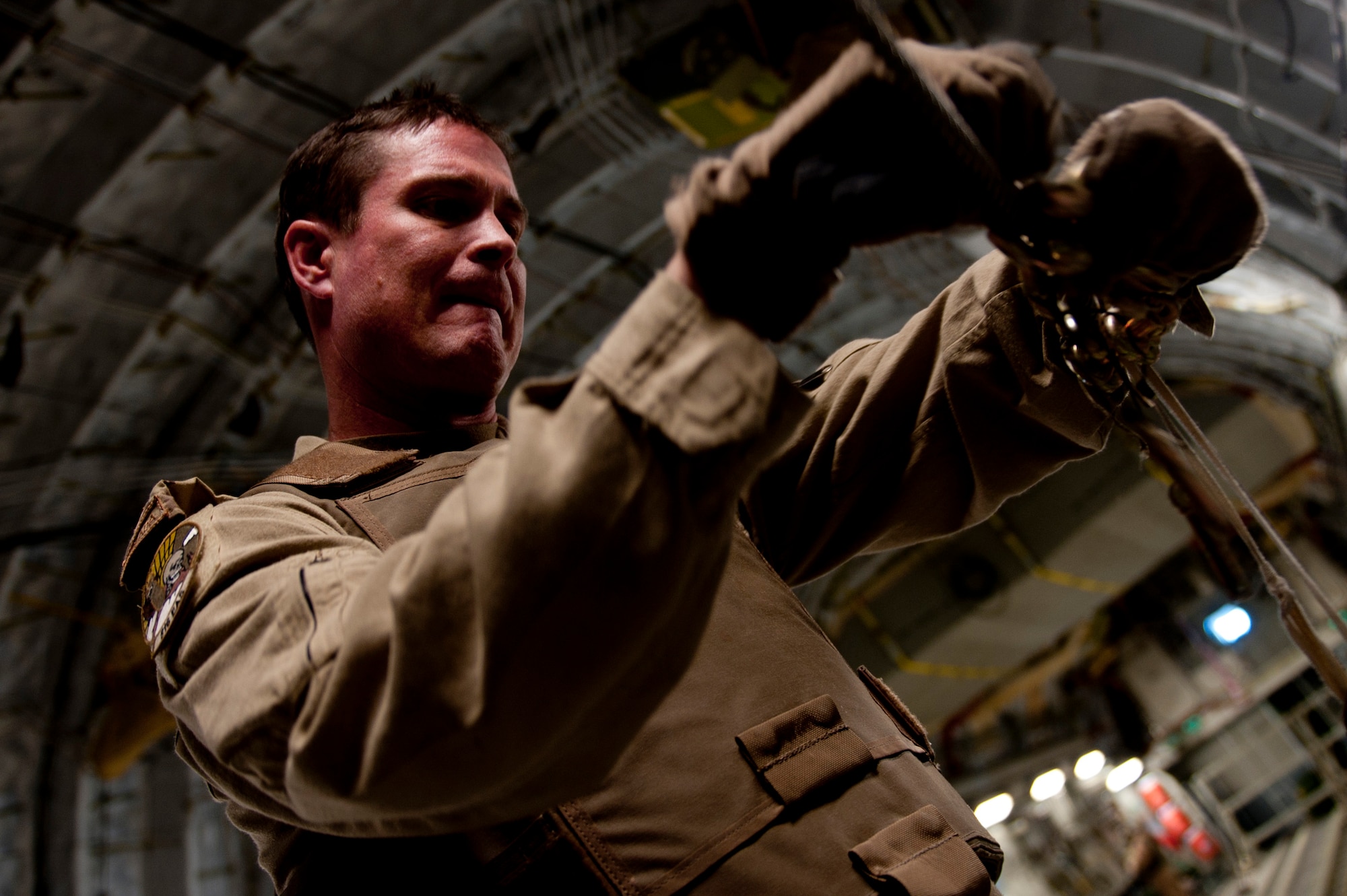 Canadian Air Force Warrant Officer David Daly, 816th Expeditionary Airlift Squadron loadmaster, disassembles an air delivery line on a C-17 Globemaster III after completing an air delivery mission. The C-17 aircrew air delivered cargo which consisted of fuel and other various supplies to a remote forward operating base in Afghanistan. Warrant Officer Daly is assigned to the American unit as part of an exchange program to better learn the C-17 airframe.
