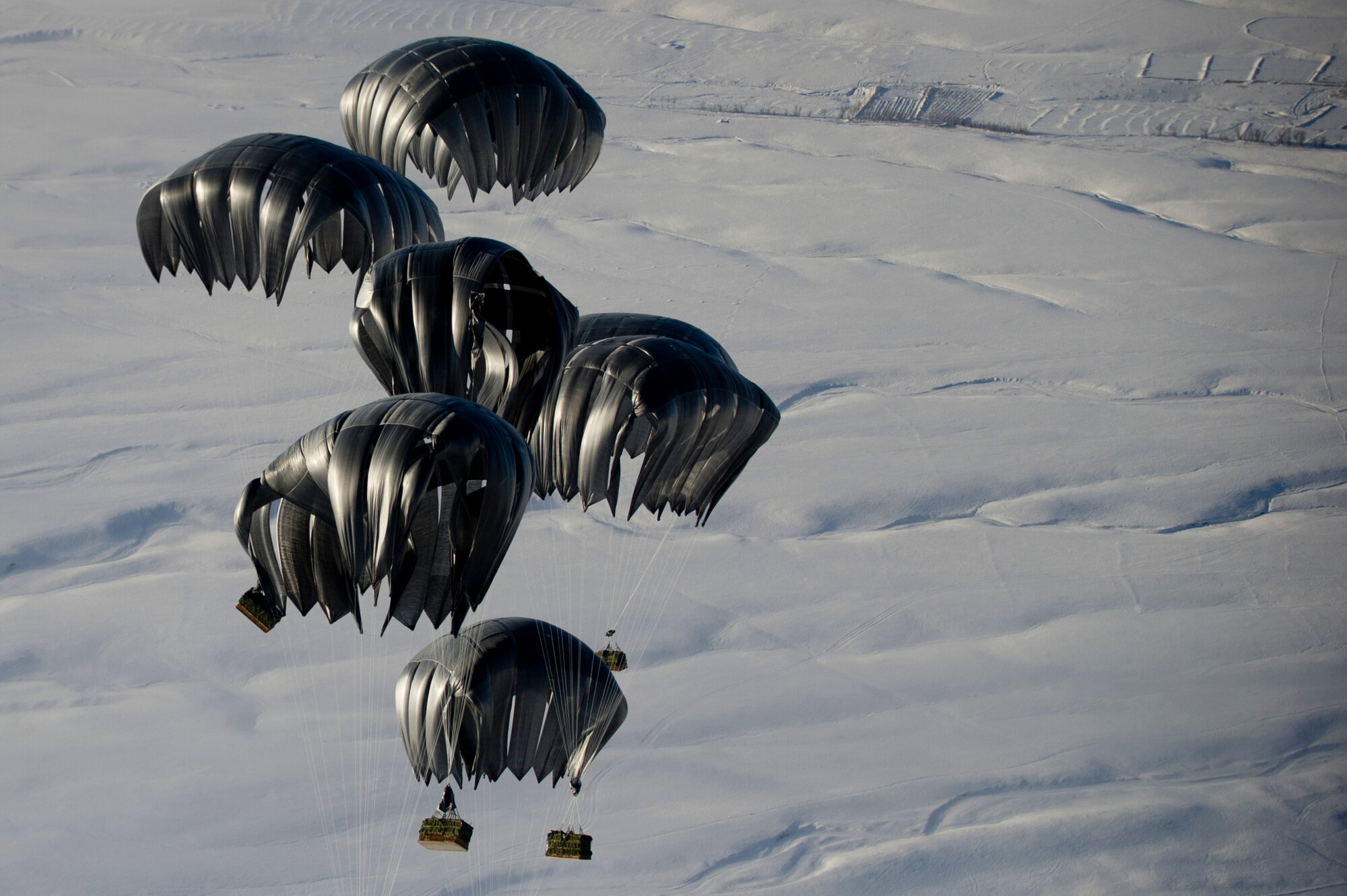 Air delivery cargo from an 816th Expeditionary Airlift Squadron C-17 Globemaster III is released over the skies of Afghanistan. The C-17 aircrew air delivered the cargo which consisted of fuel and other various supplies to a remote forward operating base in Afghanistan. The aircrew is deployed from the 7th Airlift Squadron, McChord AFB, Wash.