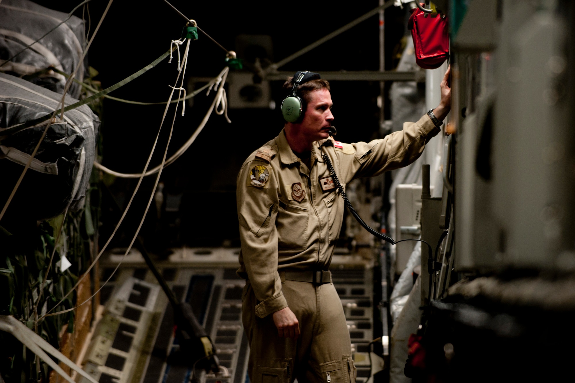 Canadian Air Force Warrant Officer David Daly, 816th Expeditionary Airlift Squadron loadmaster, checks the communication system on a C-17 Globemaster III prior to an air delivery mission into Afghanistan. The C-17 aircrew air delivered cargo which consisted of fuel and other various supplies to a remote forward operating base in Afghanistan. Warrant Officer Daly is assigned to the American unit as part of an exchange program to better learn the C-17 airframe.