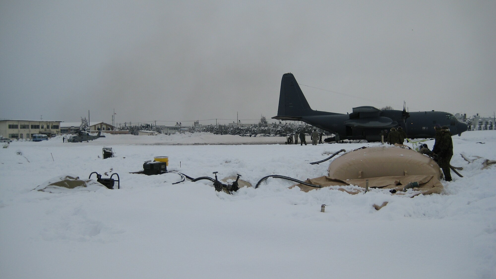 YAMAGATA, Japan -- Airmen from the 374th Logistics Readiness Squadron Fuels Management Flight work with Marines at a forward area refueling point in support of humanitarian assistance/disaster relief efforts March 18. A FARP allows aircraft to operate from airfields where fuel is not usually available. The 374th LRS sent four Airmen and an R-11 fuel truck to augment the Marines. (Courtesy photo)