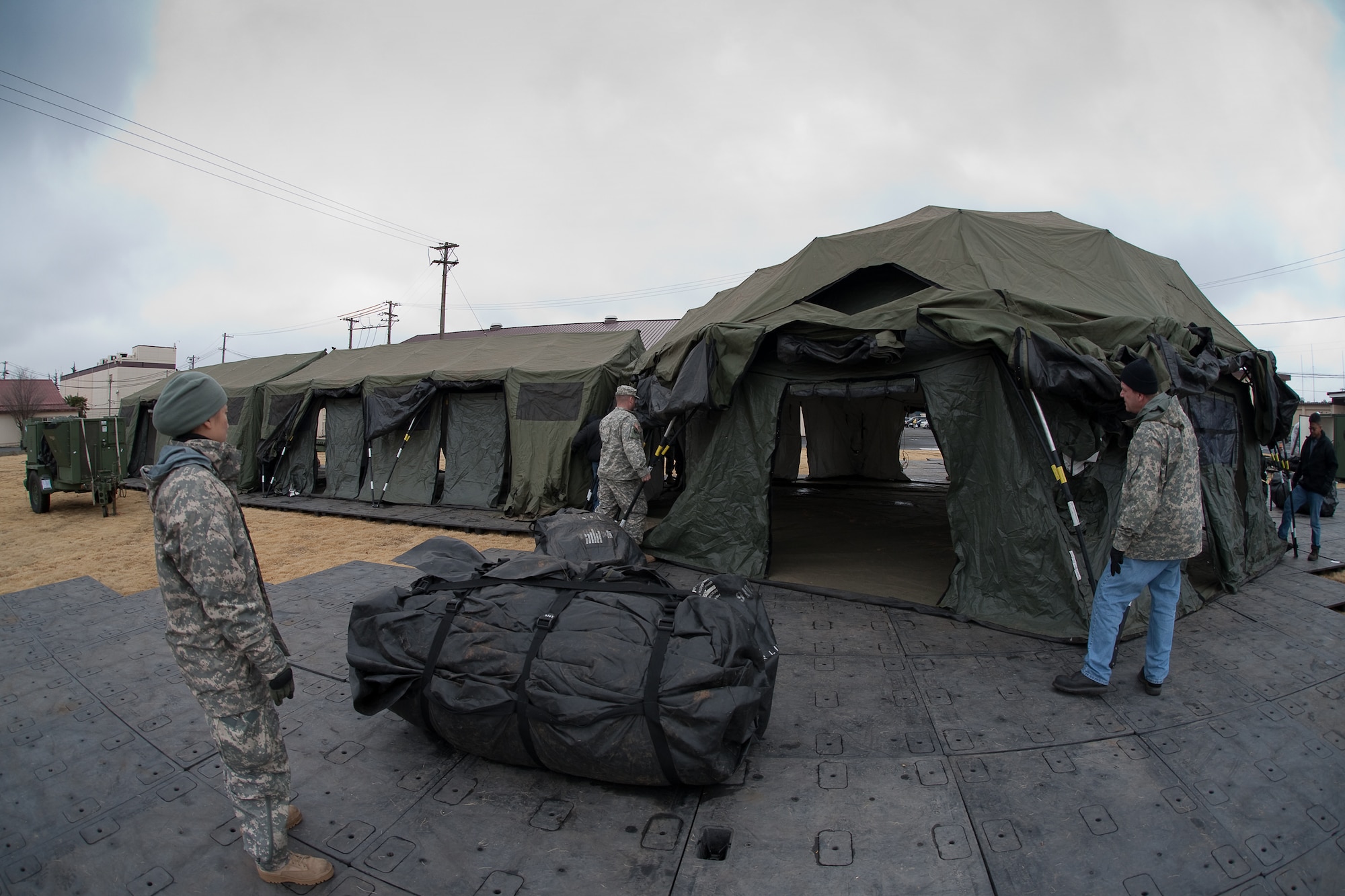 YOKOTA AIR BASE, Japan -- Pacific Command personnel build tents here, March 22. The tents will provide additional workspace for personnel deploying to Yokota in support of Operation Tomodachi. (U.S. Air Force photo/Osakabe Yasuo)