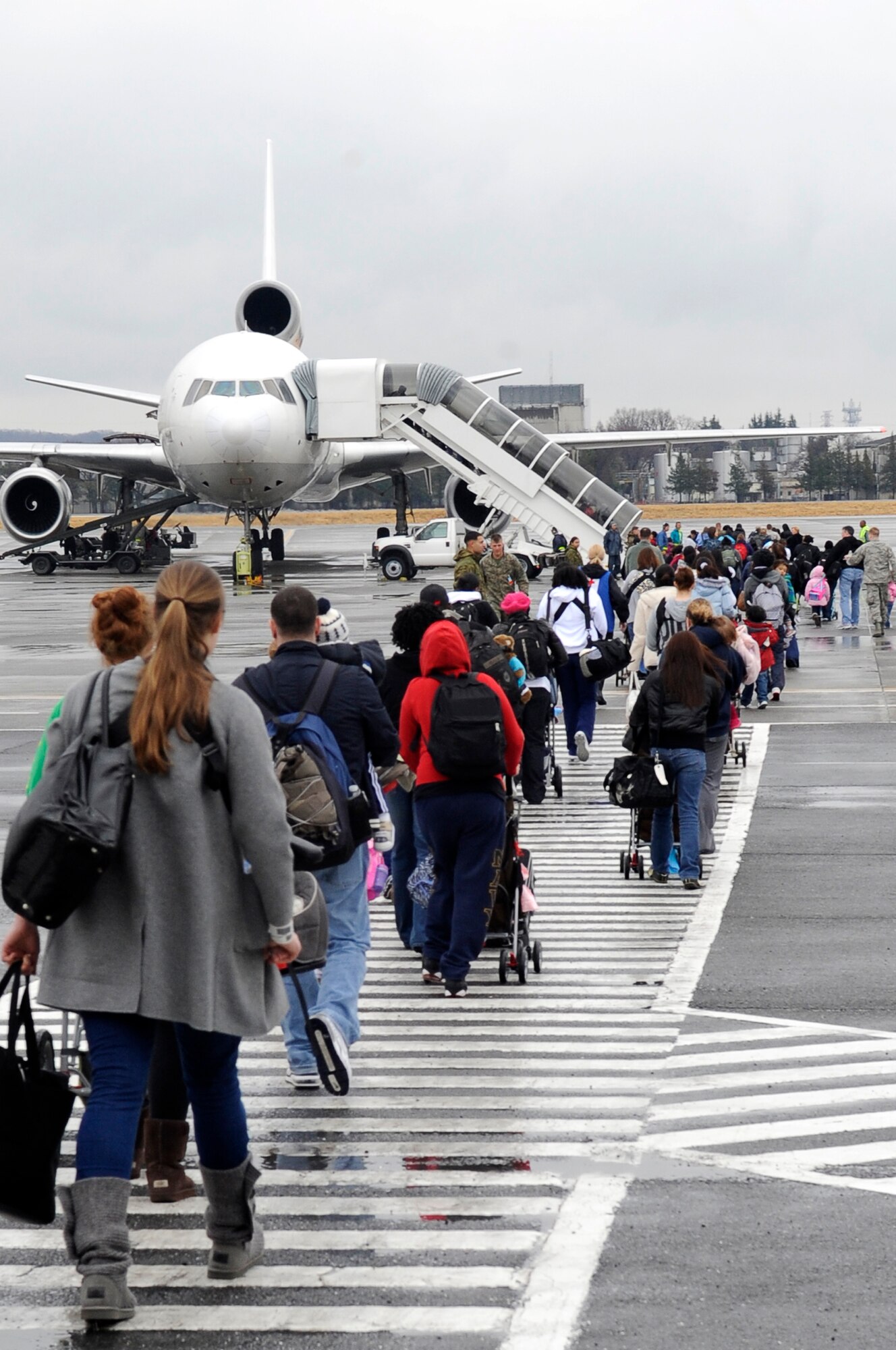 YOKOTA AIR BASE, Japan -- Military families from Fleet Activities Yokosuka, Japan, board an aircraft as part of a voluntary assisted departure March 22, 2011.The Department of State approved the voluntary authorized departure for eligible family members until the situation in Japan has resolved.  (U.S. Air Force photo/Master Sgt. Jeromy K. Cross)