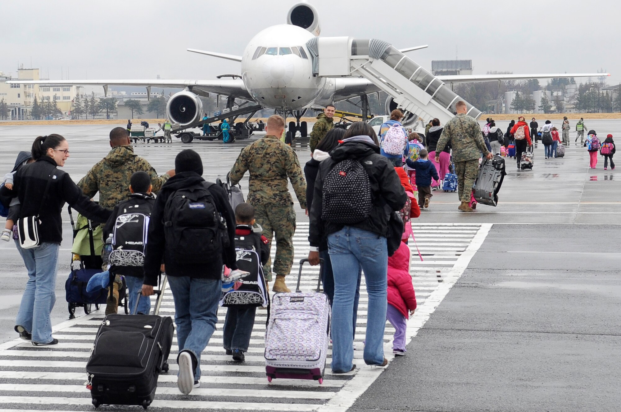 YOKOTA AIR BASE, Japan -- Military families from Fleet Activities Yokosuka, Japan, board an aircraft as part of a voluntary assisted departure March 22, 2011.The Department of State approved the voluntary authorized departure for eligible family members until the situation in Japan has resolved. (U.S. Air Force photo/Master Sgt. Jeromy K. Cross)
