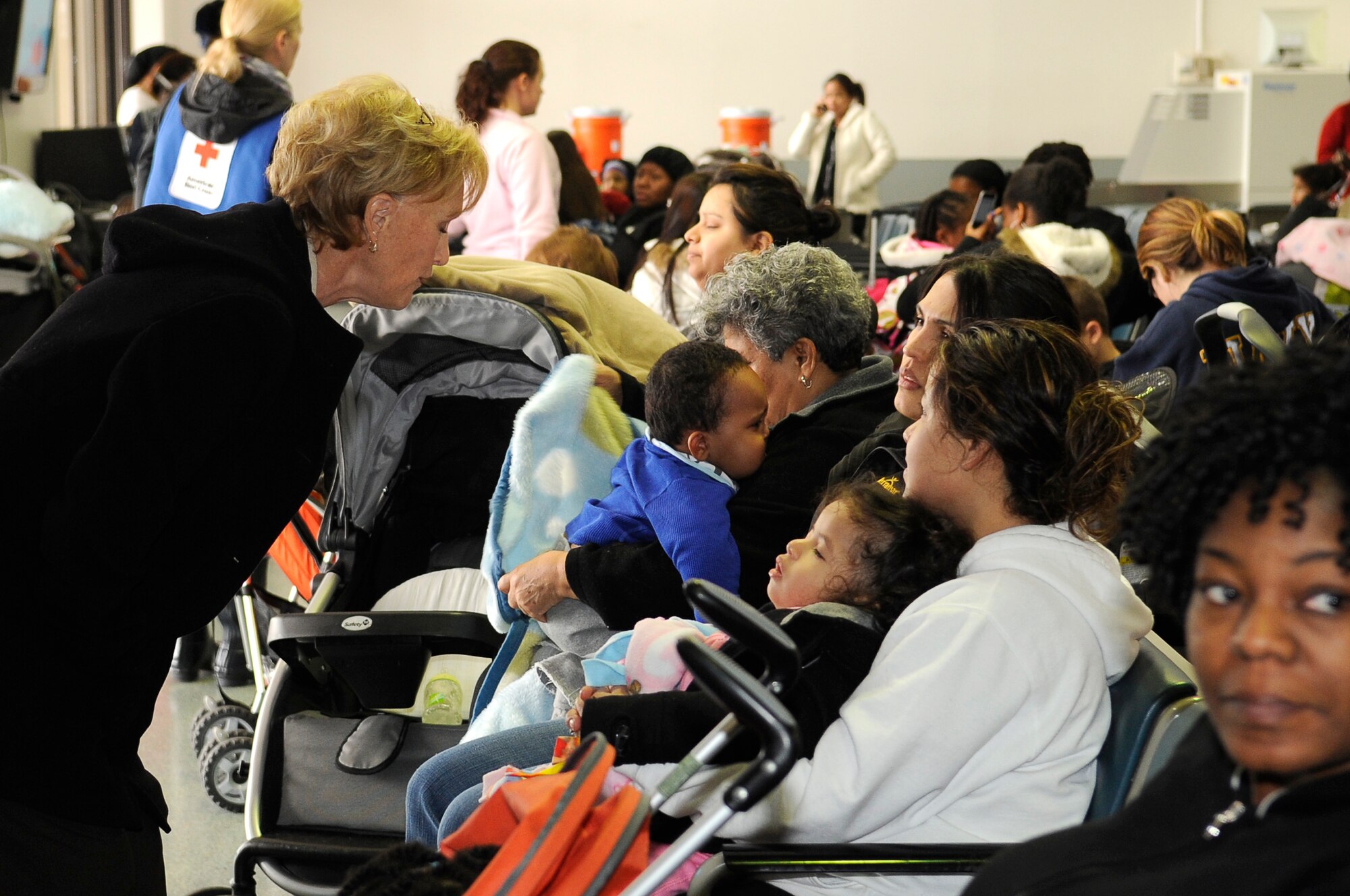 YOKOTA AIR BASE, Japan -- Mrs. Donna Willard talks with military families from Fleet Activities Yokosuka, Japan, while they wait to board a plane as part of a voluntary assisted departureMarch 22, 2011. The Department of State approved the voluntary authorized departure for eligible family members until the situation in Japan has resolved. (U.S. Air Force photo/Master Sgt. Jeromy K. Cross)

