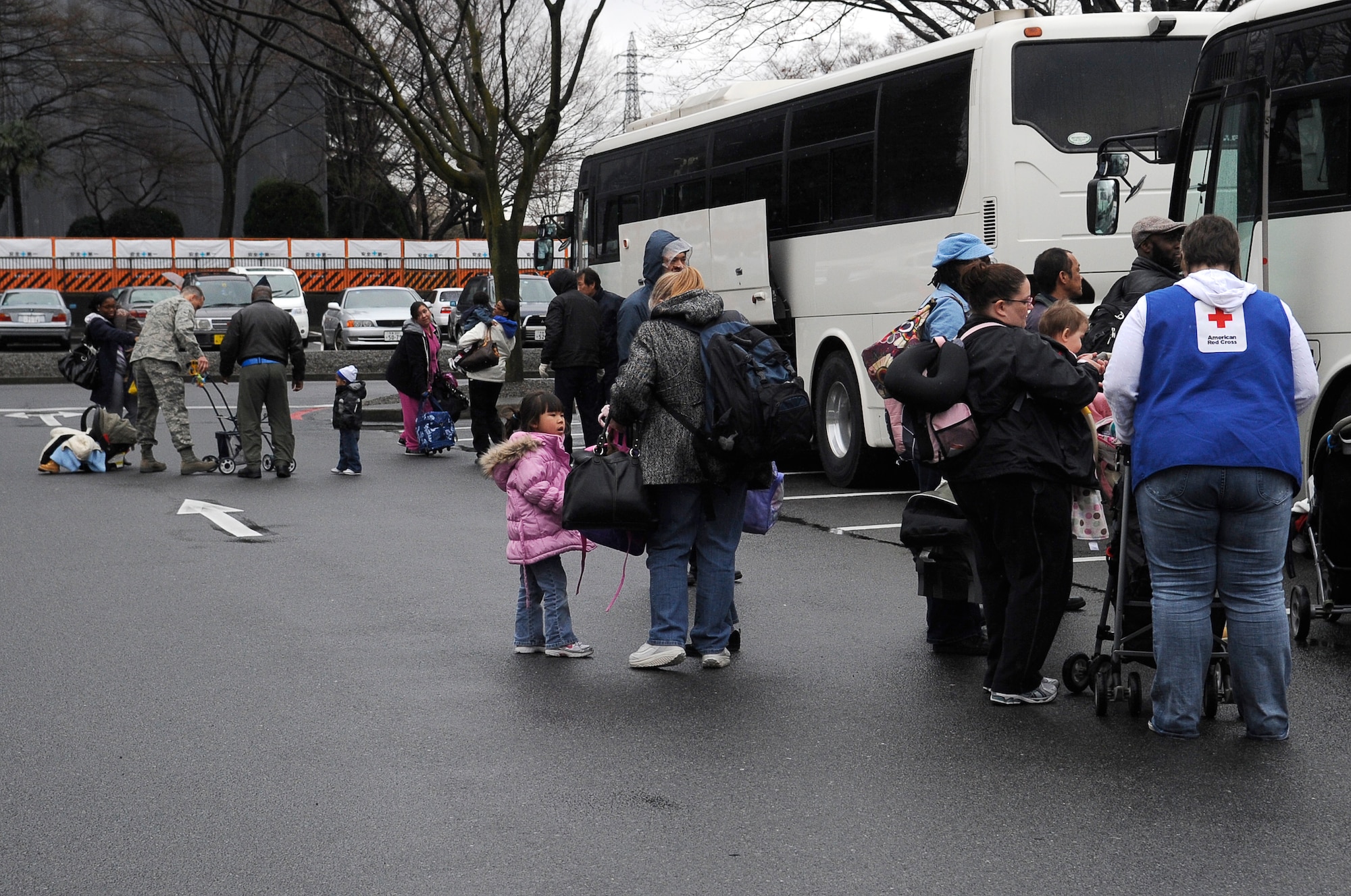 YOKOTA AIR BASE, Japan -- Military families from Fleet Activities Yokosuka, Japan, load buses at the the Enlisted Club in preparation to embark on a voluntary departure March 22, 2011. The Department of State approved the voluntary authorized departure for eligible family members until the situation in Japan has resolved. (U.S. Air Force photo/Master Sgt. Jeromy K. Cross)