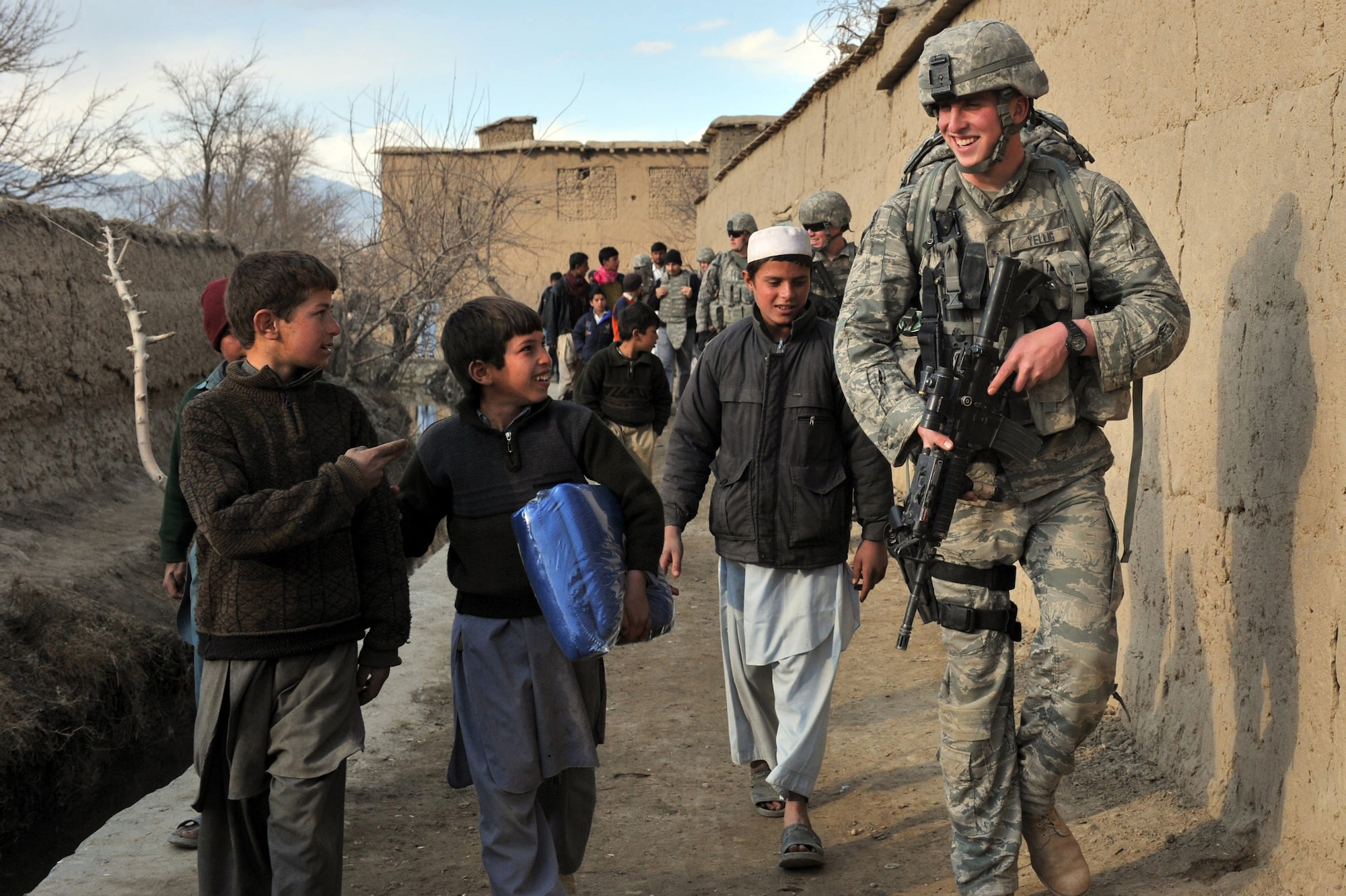 Airman 1st Class Christopher Yellig, 455th Expeditionary Security Forces Squadron, interacts with Afghan kids during a routine patrol outside Bagram Airfield, Afghanistan, Jan. 17, 2011.  Members from the 455ESFS donated blankets to the locals during the cold winter months. Airman Yellig is deployed from Ramstein Air Base, Germany. (U.S. Air Force photoby Senior Airman Sheila deVera)