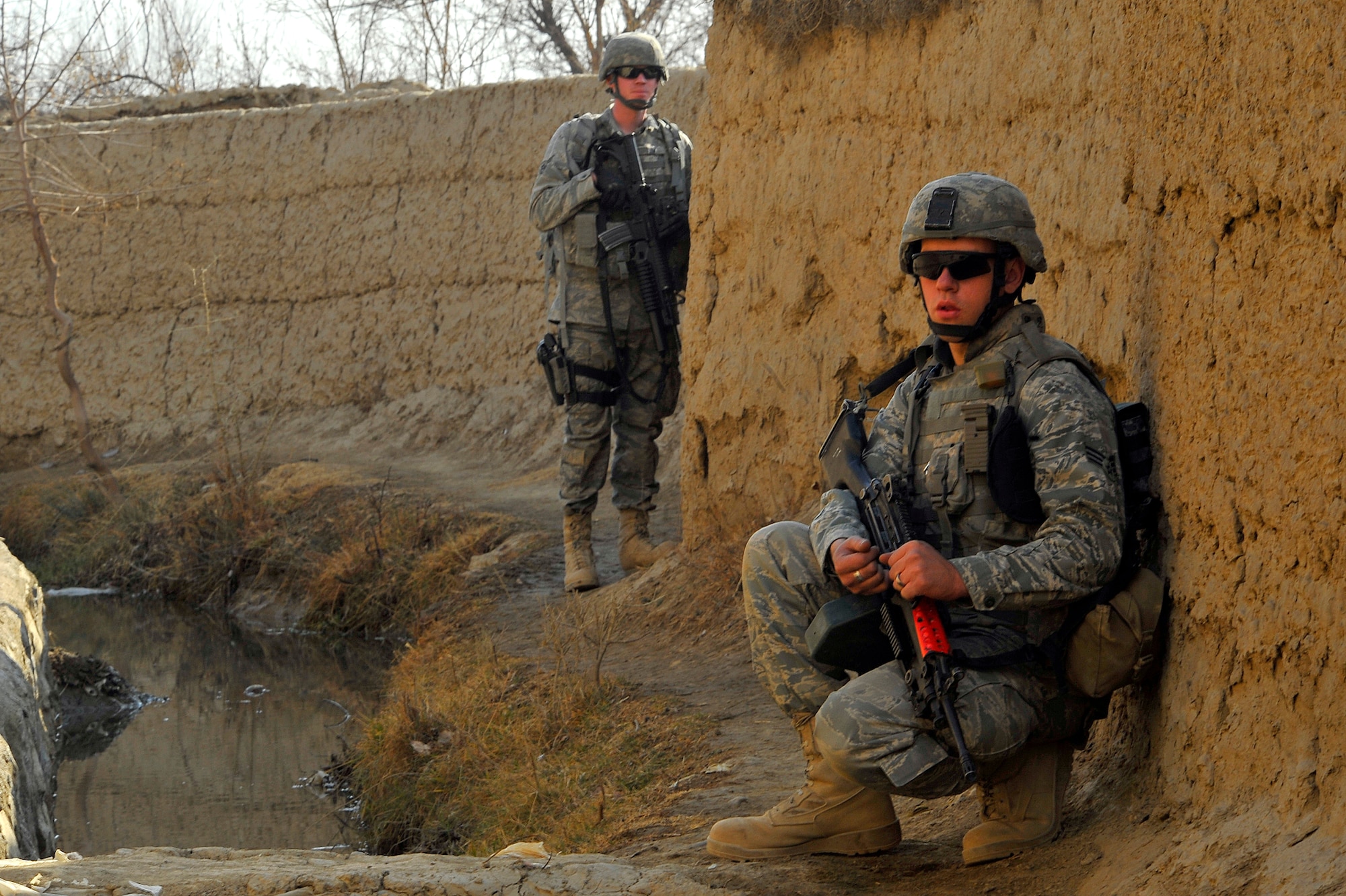 Airman 1st Class Jarren Ewing (back) and Senior Airman Stephen Jardine (front) both from the 455th Expeditionary Security Forces Squadron takea break during a routine patrol outside Bagram Airfield, Afghanistan, Jan. 17, 2011. Security Forces members visited a village to build a relationship with the Afghan locals. (U.S. Air Force photo by Senior Airman Sheila deVera)