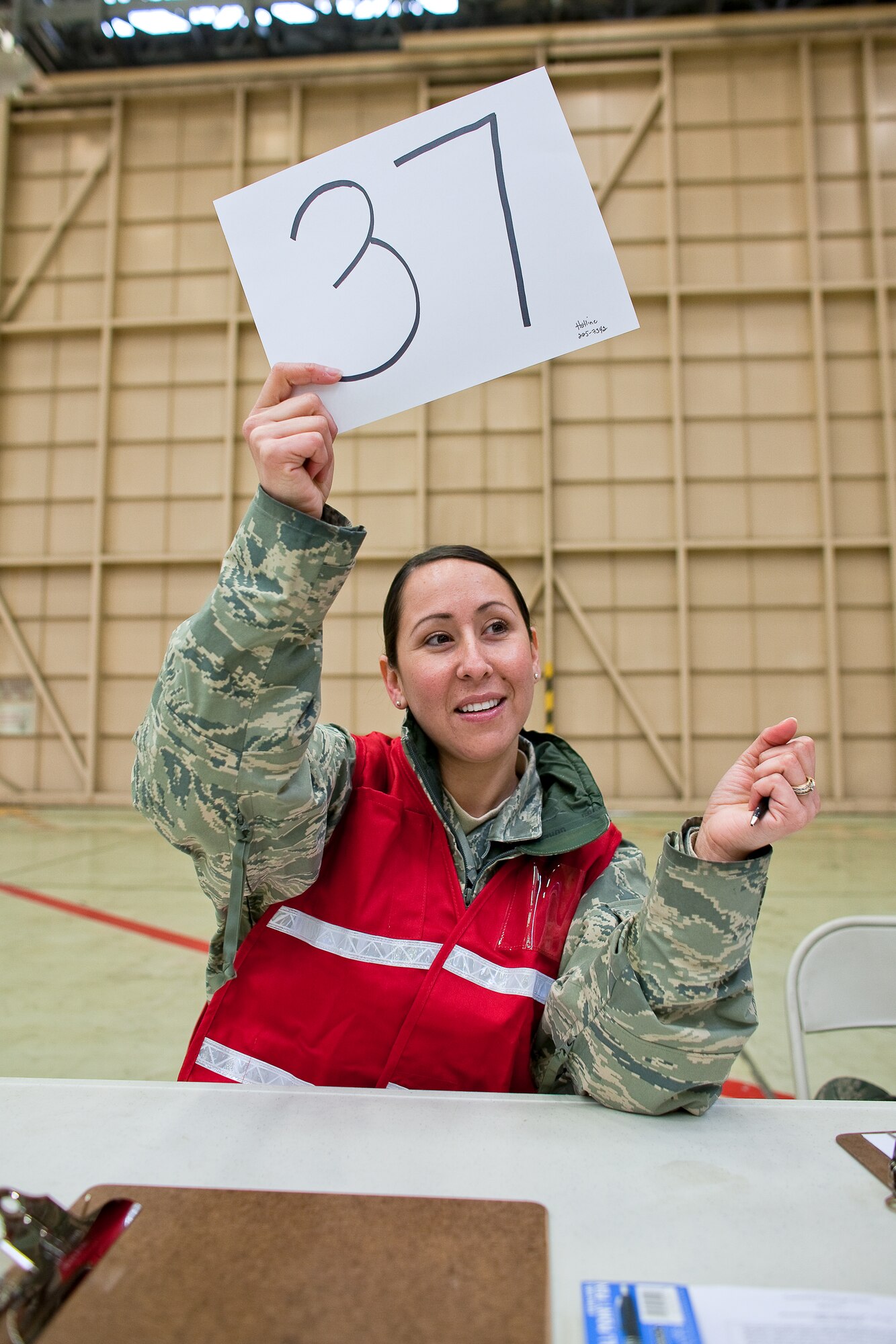 YOKOTA AIR BASE, Japan -- Staff Sgt. Michelle Romany, 374th Surgical Operations Squadron, calls for the next customer to pick up Potassium Iodide (KI) tablets here March 22. U.S. Pacific Command directed distribution of potassium iodide tablets as a precautionary measure.  Base officials are stressing there is no indication of increased exposure at Yokota AB.  Anyone wishing to receive KI tablets is required to fill out a form, available on the base Website at www.yokota.af.mil under "Japan Relief." One representative over the age of 18 can pick up packets for their entire household between 10 a.m. to 10 p.m. today at Hangar 15. For more information, call 225-7342. (U.S. Air Force photo/Osakabe Yasuo)