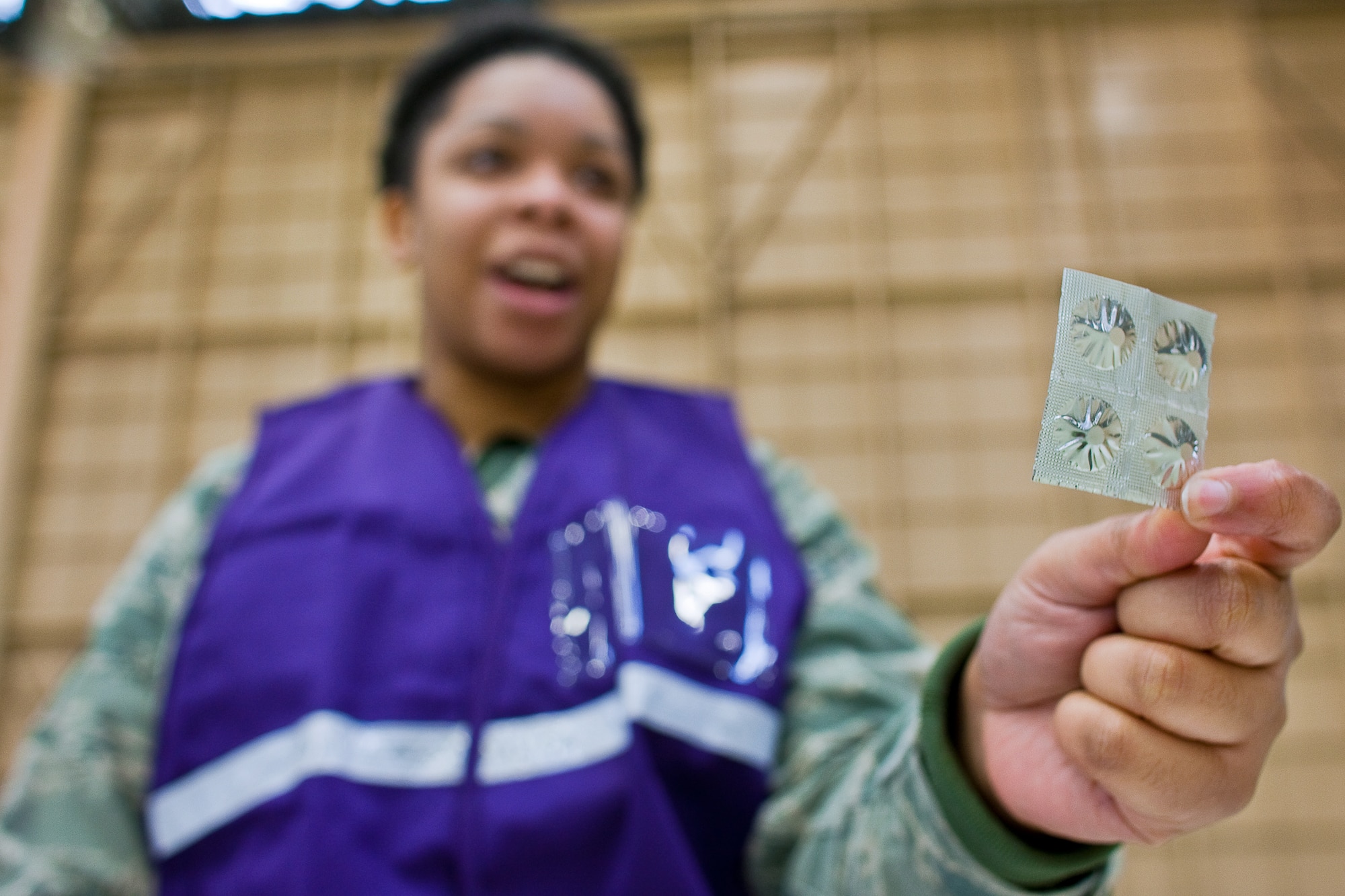 YOKOTA AIR BASE, Japan -- Staff Sgt. Alicia Tucker, 374th Medical Operations Squadron, explains how and when to take Potassium Iodide (KI) tablets here, March 22. U.S. Pacific Command directed distribution of potassium iodide tablets as a precautionary measure.  Base officials are stressing there is no indication of increased exposure at Yokota AB.  Anyone wishing to receive KI tablets is required to fill out a form, available on the base Website at www.yokota.af.mil under "Japan Relief." One representative over the age of 18 can pick up packets for their entire household between 10 a.m. to 10 p.m. today at Hangar 15. For more information, call 225-7342. (U.S. Air Force photo/Osakabe Yasuo)