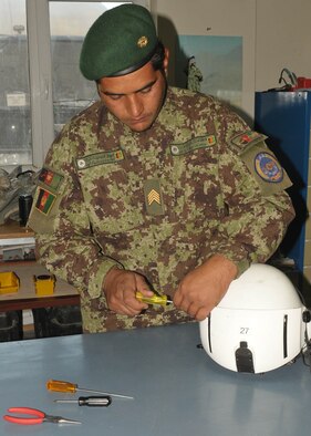 KABUL, Afghanistan - Afghan Air Force member Sgt. Gulbiddin, Life Support Specialist, puts together a helmet that will be used for Afghan Air Force life support missions in Afghanistan.  (U.S. Navy photo by Mass Communications Specialist 3rd Class Jared E. Walker)