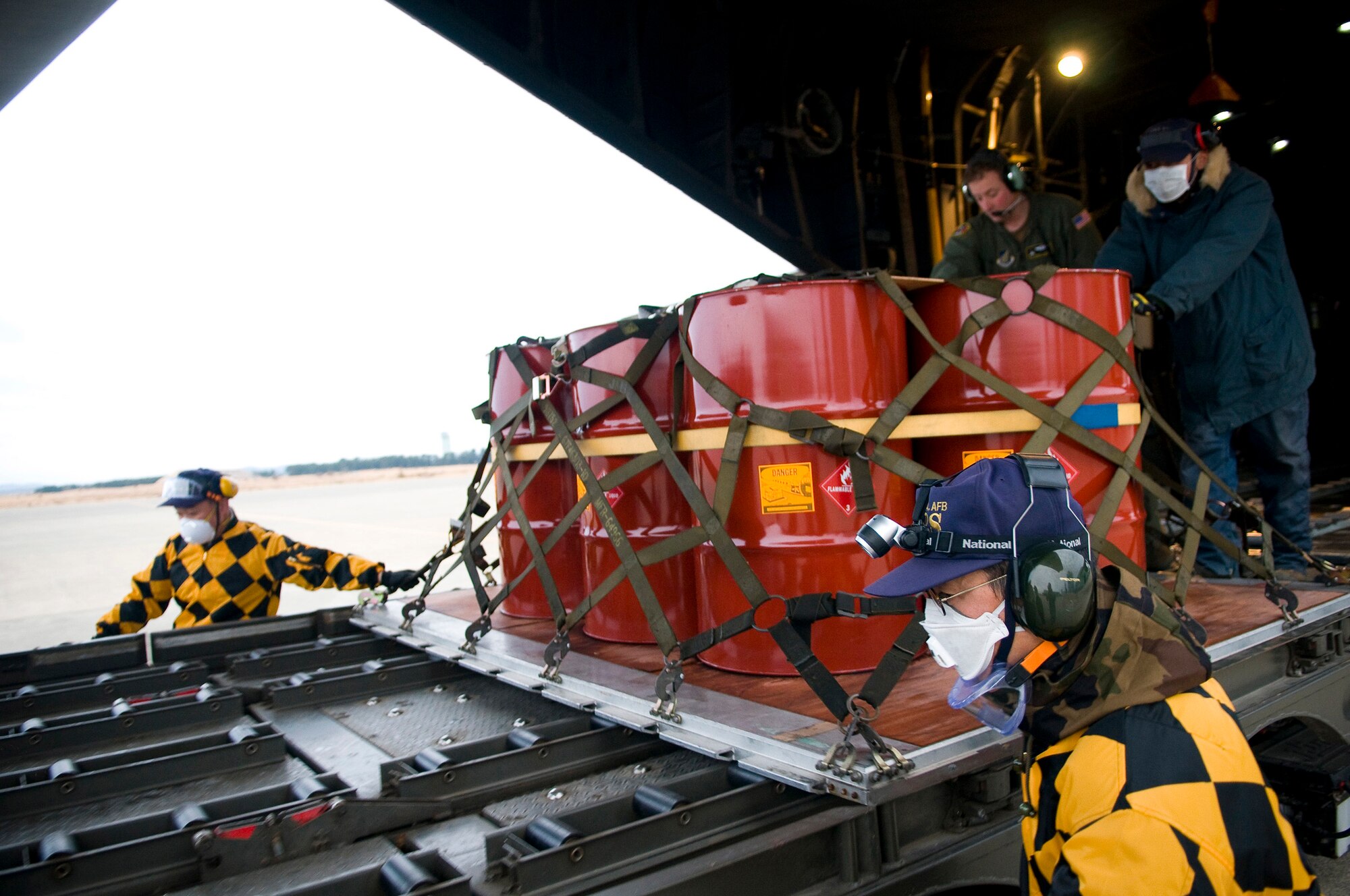 YOKOTA AIR BASE, Japan -- Staff Sgt. Charles Kirchen, 36th Airlift Squadron loadmaster, assists Japanese relief workers in unloading kerosene from a C-130H Hercules on Matsushima Air Base March 22. The kerosene was flown to Matsushima Air Base as part of Operation Tomodachi. (U.S. Air Force photo/Staff Sgt. Chad Strohmeyer)