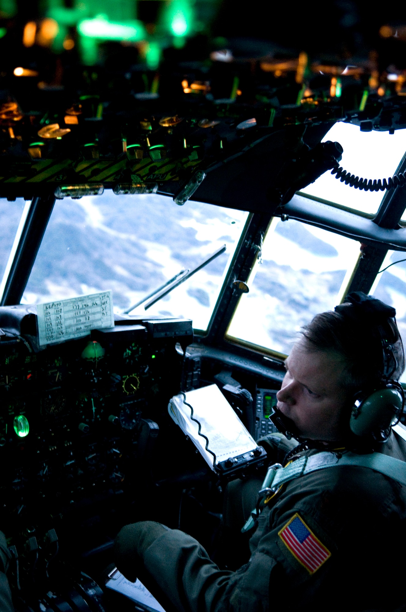 YOKOTA AIR BASE, Japan -- Major Kurt Fife, 36th Airlift Squadron pilot, looks out his side window to assess damage from the earthquake and tsunami March 22 while flying on a C-130H Hercules full of kerosene to Matsushima Air Base. The kerosene will be used to fuel heaters at relief shelters in northern Japan, where temperatures have repeatedly dropped below freezing. (U.S. Air Force photo/Staff Sgt. Chad Strohmeyer)