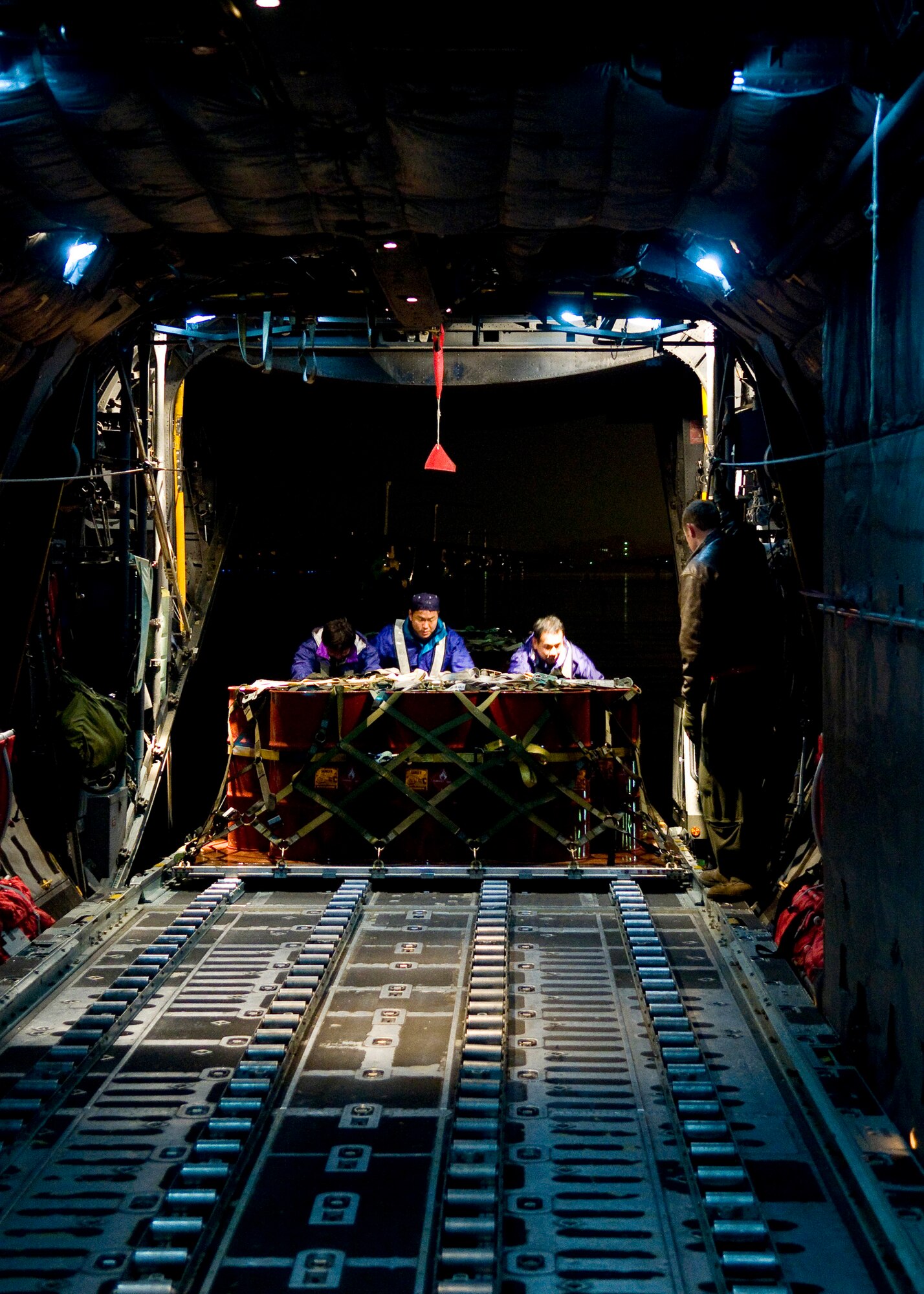 YOKOTA AIR BASE, Japan -- Staff Sgt. Charles Kirchen, 36th Airlift Squadron loadmaster, assists Japanese relief workers in loading kerosene onto a C-130H Hercules at Iruma Air Base March 22. The kerosene was flown to Matsushima Air Base as part of Operation Tomodachi. (U.S. Air Force photo/Staff Sgt. Chad Strohmeyer)