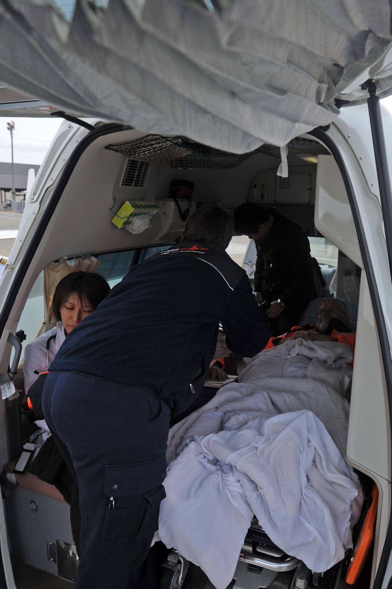 MISAWA AIR BASE, Japan -- Nurses from Switzerland's Air-Ambulance assists with the transfer of Maurer Bruno from the vehicle to the plane after his emergency surgery at the Hachinohe Medical Center. Bruno was helping out for ten days with the recovery efforts in northern Japan prior to his emergency surgery at the Hachinohe Medical Center.  (U.S. Air Force photo by Staff Sgt. April Quintanilla\Released)
