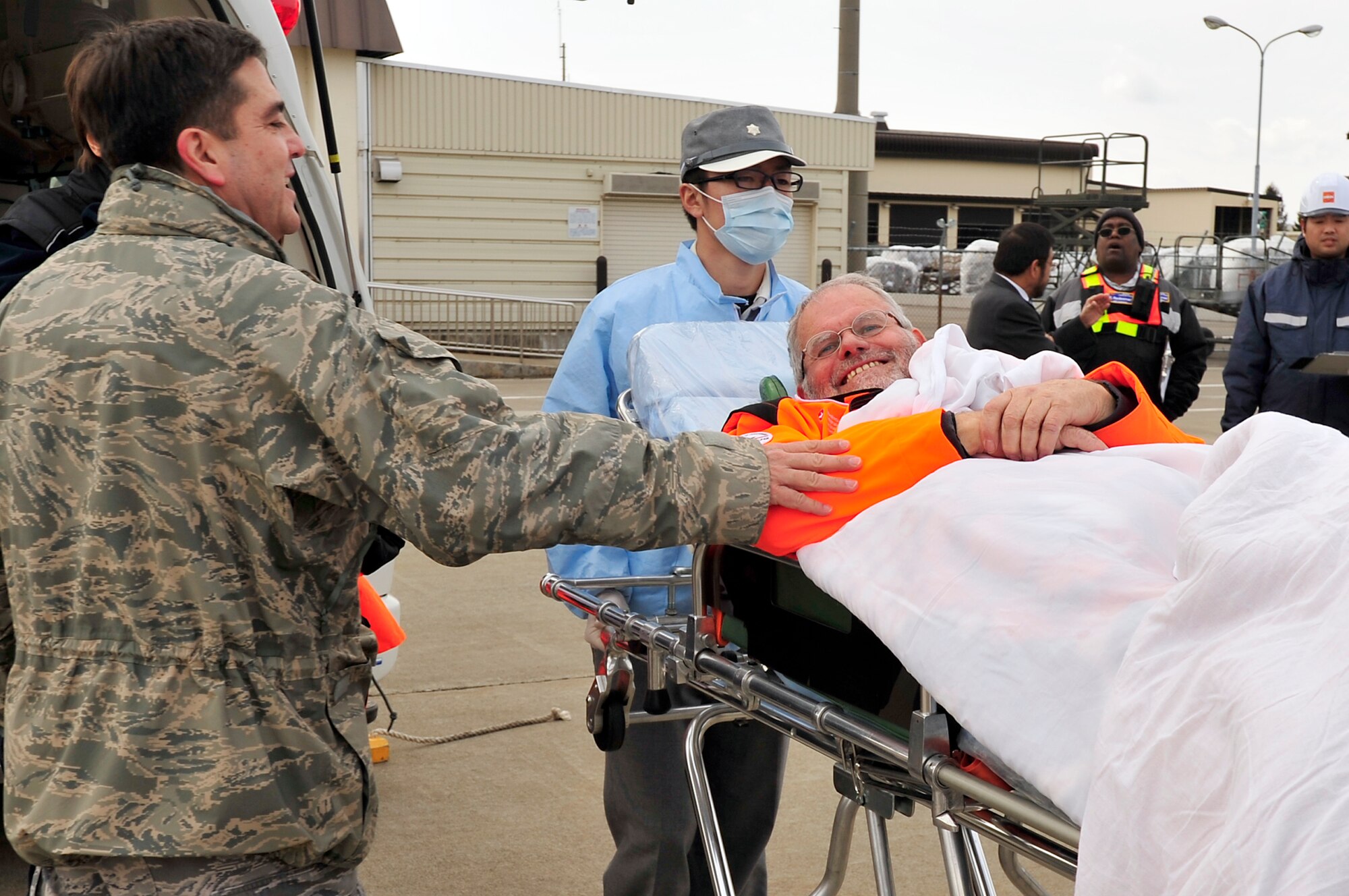 MISAWA AIR BASE, Japan -- Col. Guillermo Tellez, 35th Medical Group commander, says goodbye to Maurer Bruno, Swiss Search and Rescue team volunteer, on the flightline Mar. 21. Bruno has been supporting search and recovery efforts for ten days before he was medically evacuated due to an emergency surgery that was performed at the Hachinohe medical center.  (U.S. Air Force photo by Staff Sgt. Marie Brown\Released)
