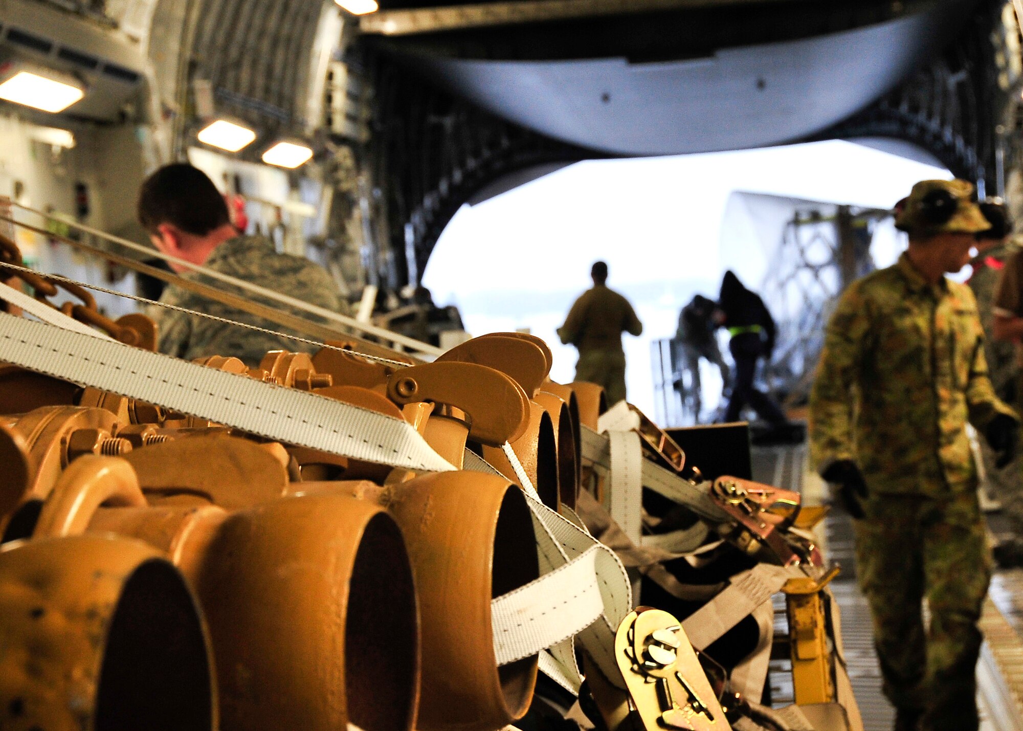 YOKOTA AIR BASE, Japan -- U.S. Air Force and Royal Australian Air Force members unload water pumps from a RAAF C-17 Globemaster III here March 22. The pumps will be used to support relief operations following the earthquake and tsunami that struck Japan March 11. (U.S. Air Force photo/Airman 1st Class Andrea Salazar)