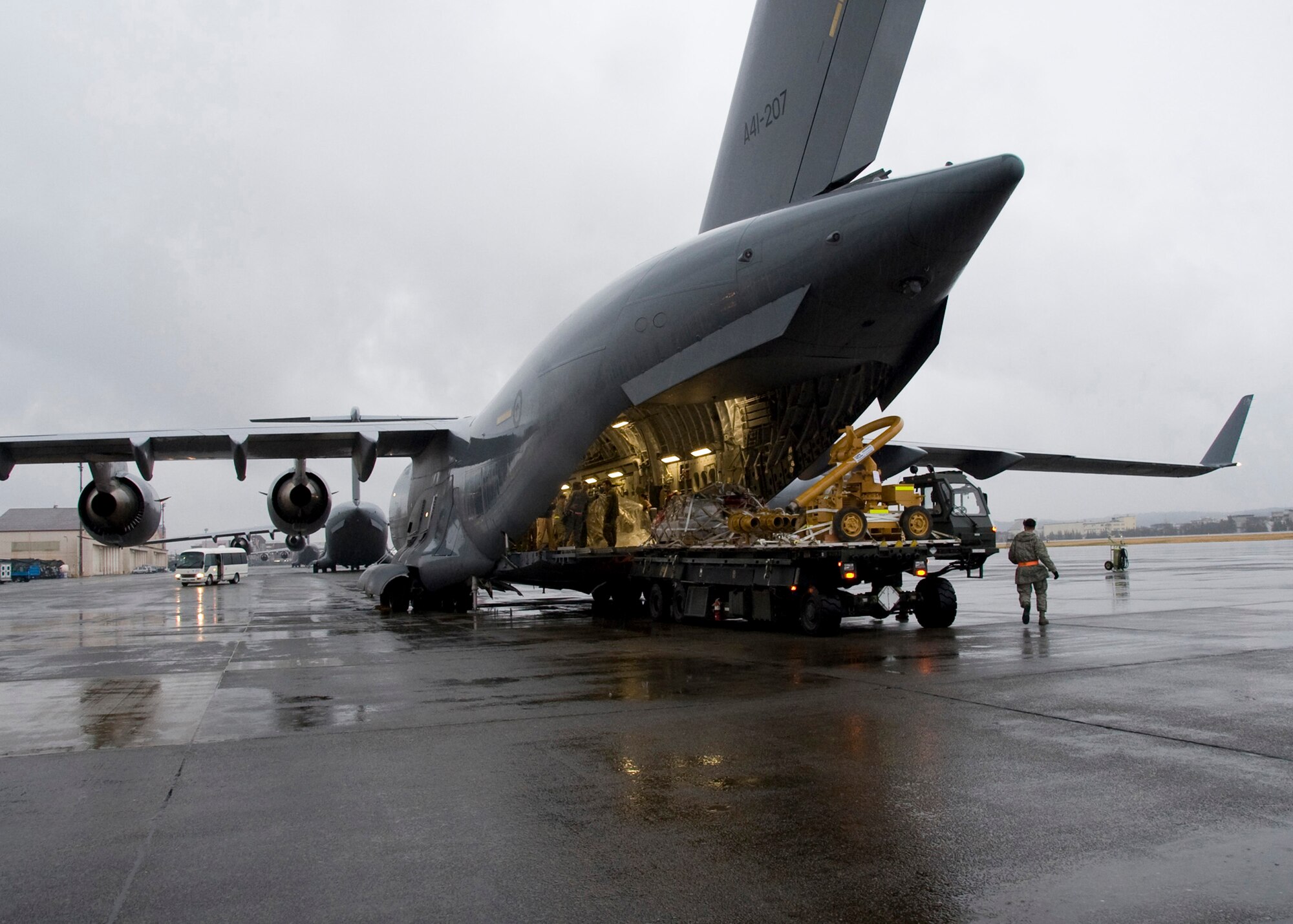 YOKOTA AIR BASE, Japan -- U.S. Air Force and Royal Australian Air Force members unload water pumps from a RAAF C-17 Globemaster III here March 22. The pumps will be used to support relief operations following the earthquake and tsunami that struck Japan March 11. (U.S. Air Force photo/Airman 1st Class Andrea Salazar)