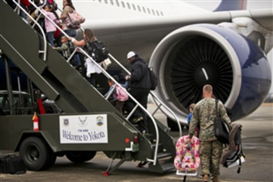 Dependents of U.S. service members board a plane during a voluntary authorized departure from Yokota Air Base, Japan, March 22, 2011. The Defense Department is implementing voluntary authorized departures for eligible dependents stationed on the island of Honshu, Japan.