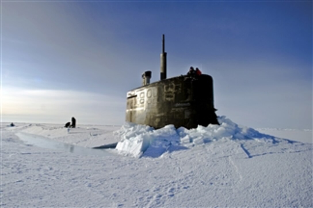 U.S. Navy sailors and members of the Applied Physics Laboratory Ice Station clear ice from the hatch of the USS Connecticut (SSN 22) as it surfaces above the ice in the Arctic Ocean on March 19, 2011.  The submarine and crew are participating in Ice Exercise 2011, which tests submarine operations in the Arctic.  