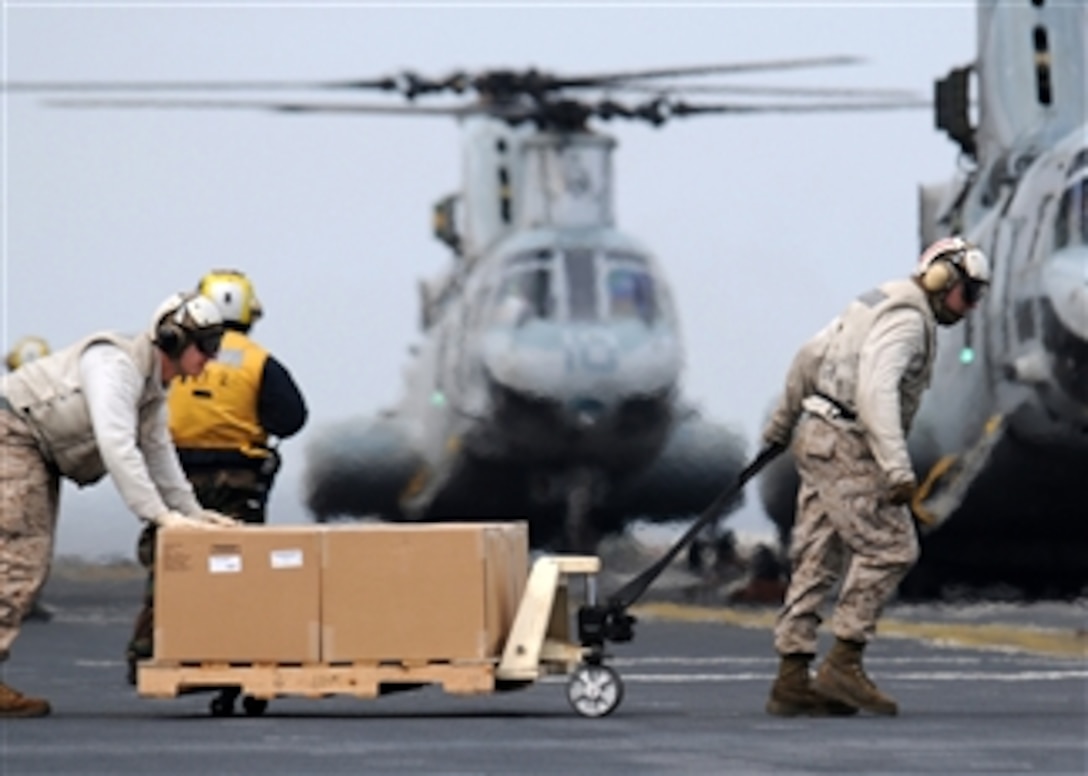 U.S. Marines move humanitarian and disaster relief supplies to load them into a Marine Corps CH-46E Sea Knight helicopter on the flight deck of the amphibious assault ship USS Essex (LHD 2) off the coast of Hachinohe in northeastern Japan on March 21, 2011.  The Marines are working in support of Operation Tomodachi, the U.S. military's humanitarian and relief effort in response to the 9.0-magnitude earthquake and tsunami that struck Japan on March 11.  