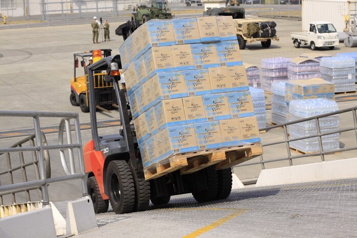 Combat Logistics Company 36 unloads more than 230 tons of palletized bottled water here, March 22, to be transported via KC-130J aircraft to Sendai, Japan, in support of Operation Tomodachi. Operation Tomodachi is a joint humanitarian assistance operation implimented by the U.S. Armed Forces and Japan to provide aid following the approximately 9.0 magnitude earthquake and subsequent tsunami in the Tohoku region of northern Japan, March 11. Since relief efforts began, more than 1.5 million pounds of food, water, cargo, supplies and equipment have been prepared and transported via air, land and sea to support affected areas.
