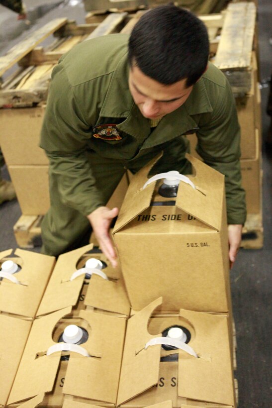 A Marine with the Marine Medium Helicopter Squadron 262, 31st Marine Expeditionary Unit, stacks boxes of water jugs in the hanger bay aboard the forward deployed amphibious assault ship U.S.S. Essex (LHD-2), during Operation Tomodachi, March 23. Navy and Marine Corps involvement is part of a larger U.S. government response, coordinated with the government of Japan's ongoing relief efforts, after a 9.0 earthquake and subsequent tsunami struck Japan causing widespread damage. As part of Operation Tomodachi, the 31st MEU is ready to support our Japanese partners and to provide assistance when called upon.