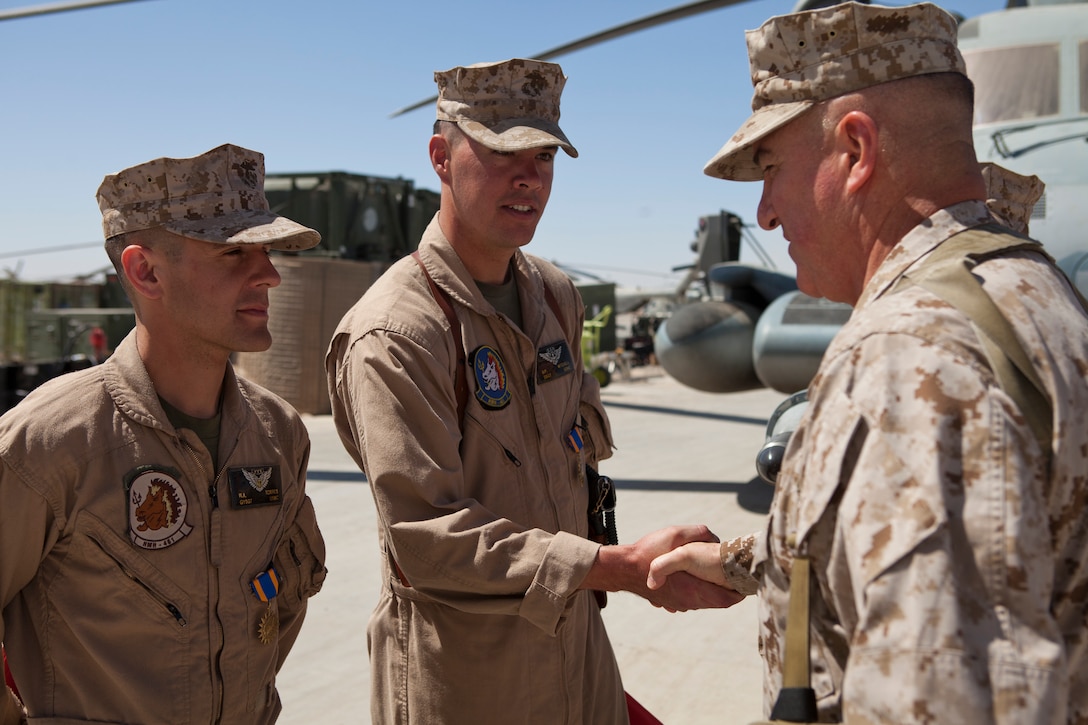Brig. Gen. Glenn M. Walters shakes hands with Air Medal awardee, Staff Sgt. Shawn P. Mitchel following an awards ceremony at Camp Bastion, Afghanistan, March 23. Mitchell was one of eight Marines awarded for participating in a tactical recovery of  aircraft and personnel mission. Walters is the commanding general of 2nd Marine Aircraft Wing (Forward) and Mitchell is a CH-53E crew chief.