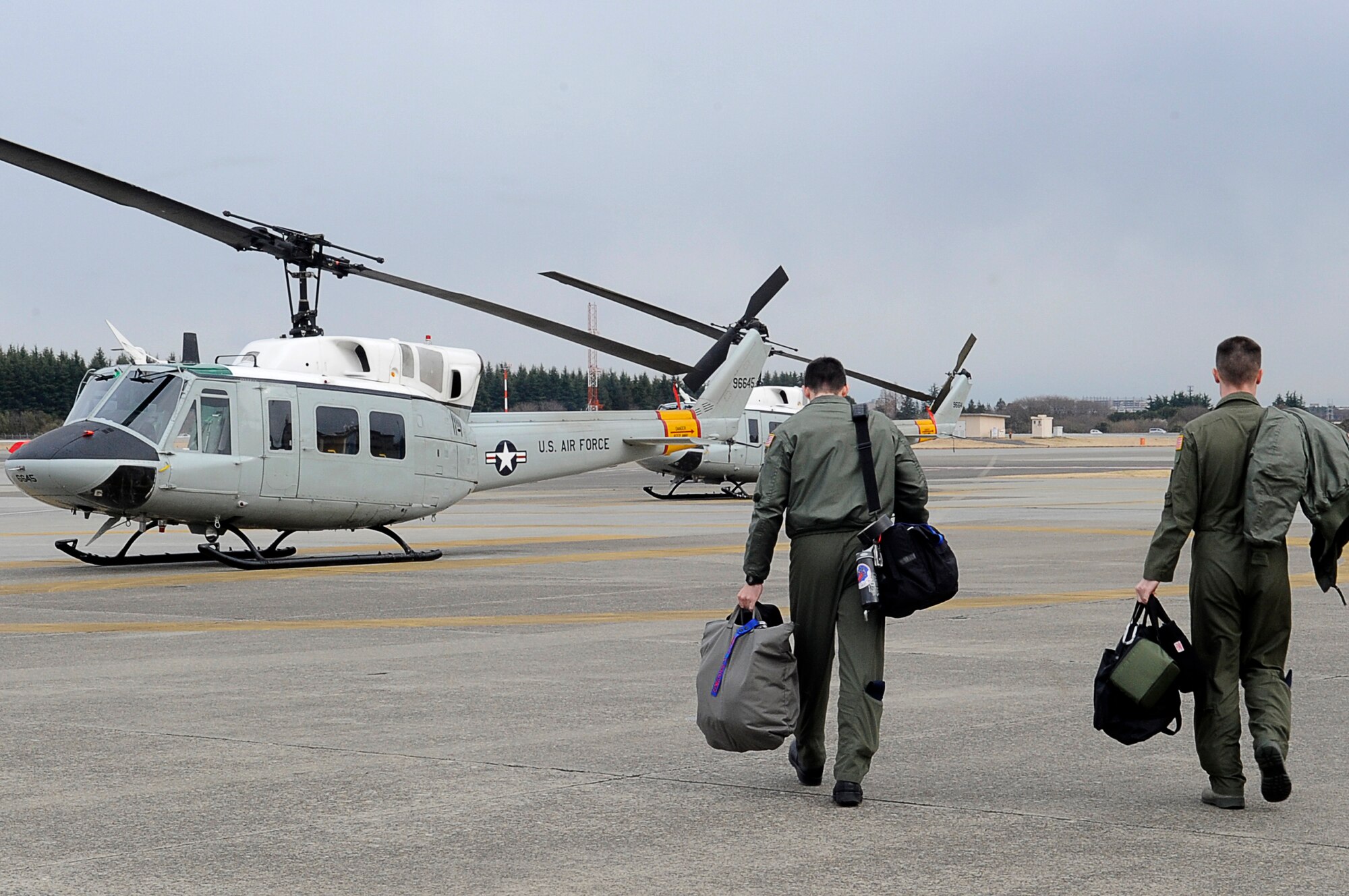 YOKOTA AIR BASE, Japan -- Airmen from the 459th Airlift Squadron walk out to their UH-1 Huey helicopter at Yokota, in preparation for a flight to Tokyo, March 23. The helicopters are critical in providing logistical support by transporting general officers, Department of Energy personnel and other officials in support of Operation Tomodachi. (U.S. Air Force photo/Master Sgt. Jeromy K. Cross/released)





