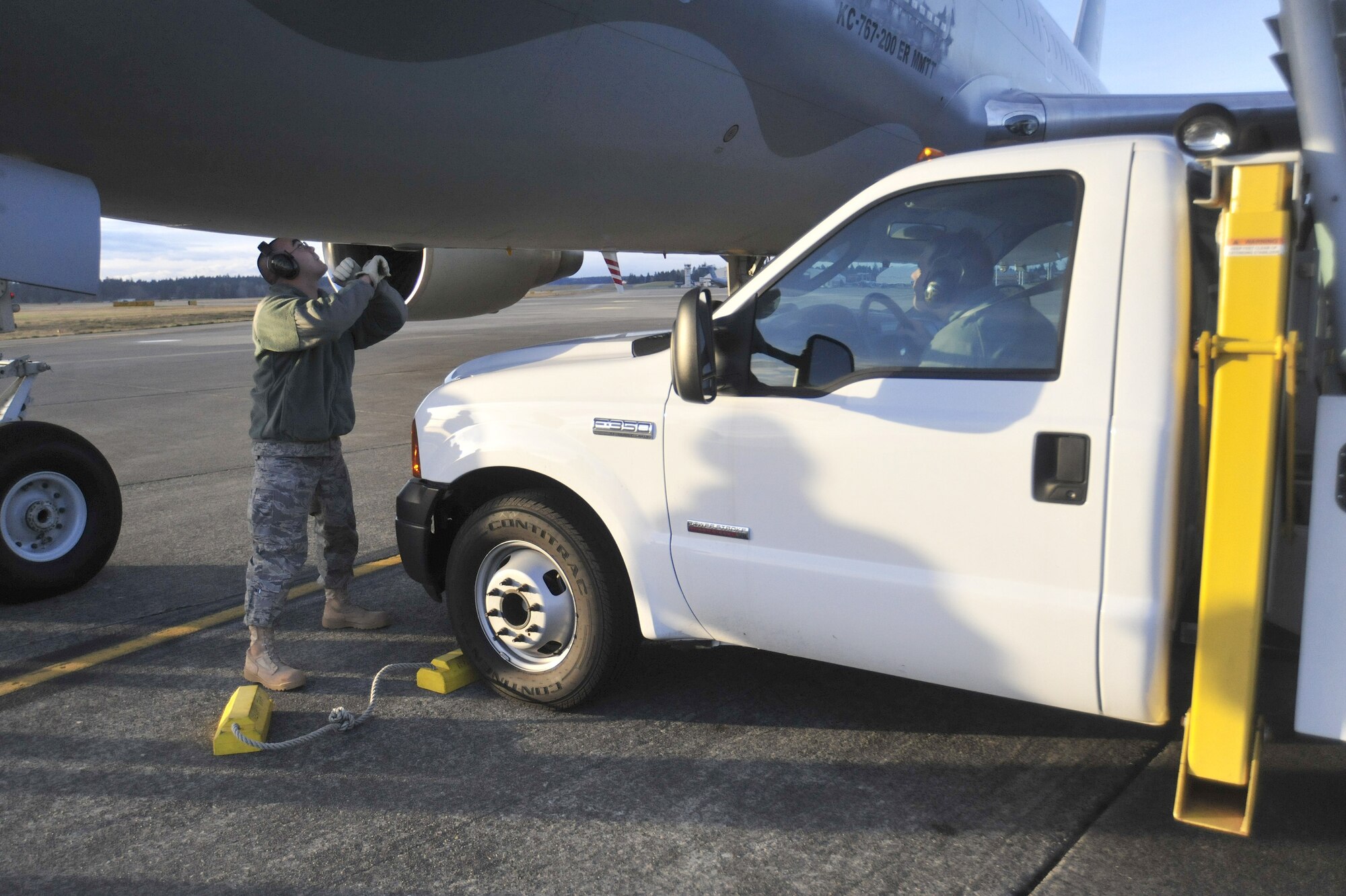 Airmen assigned to the 62nd Aerial Port Squadron prepare to unload passengers from a Columbian aircraft March 22, 2011, at Joint Base Lewis-McChord, Wash. The aircraft landed at McChord Field for refueling while moving more than 190 passengers from Japan’s Narita International Airport to Columbia. (U.S. Air Force photo/Airman 1st Class Leah Young)