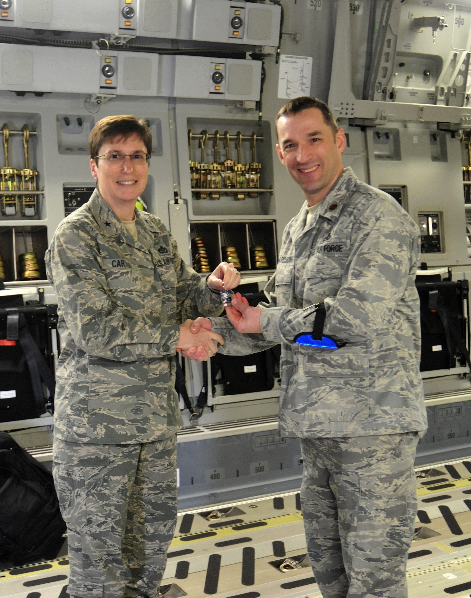 Brig. Gen. Theresa Carter, left, Air Mobility Command director of installations and mission support, hands the key to a new C-17 Globemaster III to Maj. Duane Richardson, 62nd Aircraft Maintenance Squadron operations officer, at a ceremonial tradition March 22, 2011, at Joint Base Lewis-McChord, Wash. (U.S. Air Force photo/Airman 1st Class Leah Young)