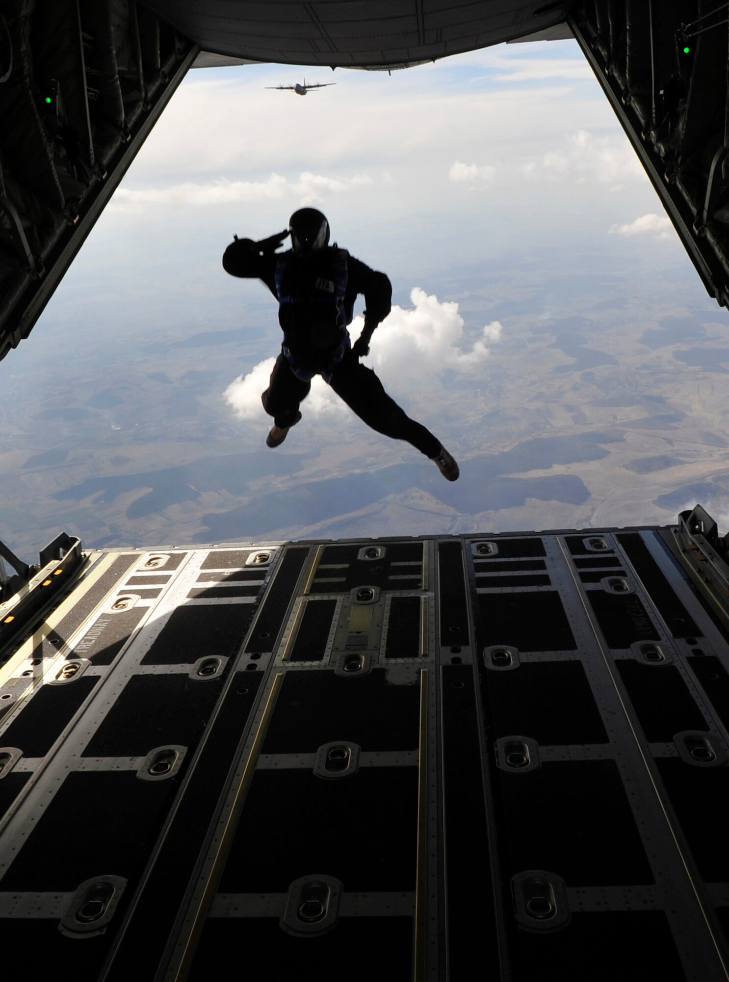 Master Sgt. Robert Zackery salutes as he exits a C-130J Super Hercules during a combined high-altitude, low-open, jump March 18, 2011, over a landing zone near Campia Turzii, Romania. This jump was conducted as part of Carpathian Spring 2011, an exercise where members of the U.S. military joined their Romanian counterparts to learn from one another and strengthen alliances. Sergeant Zackery is a jumpmaster assigned to the 4th Air Support Operations Group. (U.S. Air Force photo/Tech. Sgt. Jocelyn L. Rich)