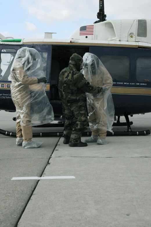 Airmen from the 1st Helicopter Squadron don plastic bags to minimalize cross contamination in a disbursement exercise in which assets from Joint Base Andrews were relocated after a simulated chemical attack on the capitol region. (U.S. Air Force photo by Senior Airman Torey Griffith)