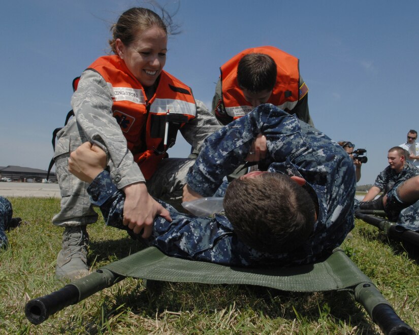 Capt. Holly Kingston assists a simulated victim onto a litter during a Mass
Accident Response Exercise at Joint Base Charleston, SC, Mar. 22. The MARE
is a necessary step to prepare all Joint Base Charleston members for the
upcoming 2011 Air Expo. The exercise is used to help test and train the
supporting agencies who would respond in case of an emergency. Capt.
Kingston is assigned to 628th Medical Group (U.S. Air Force photo by Senior
Airman Brianna Veesart) 

