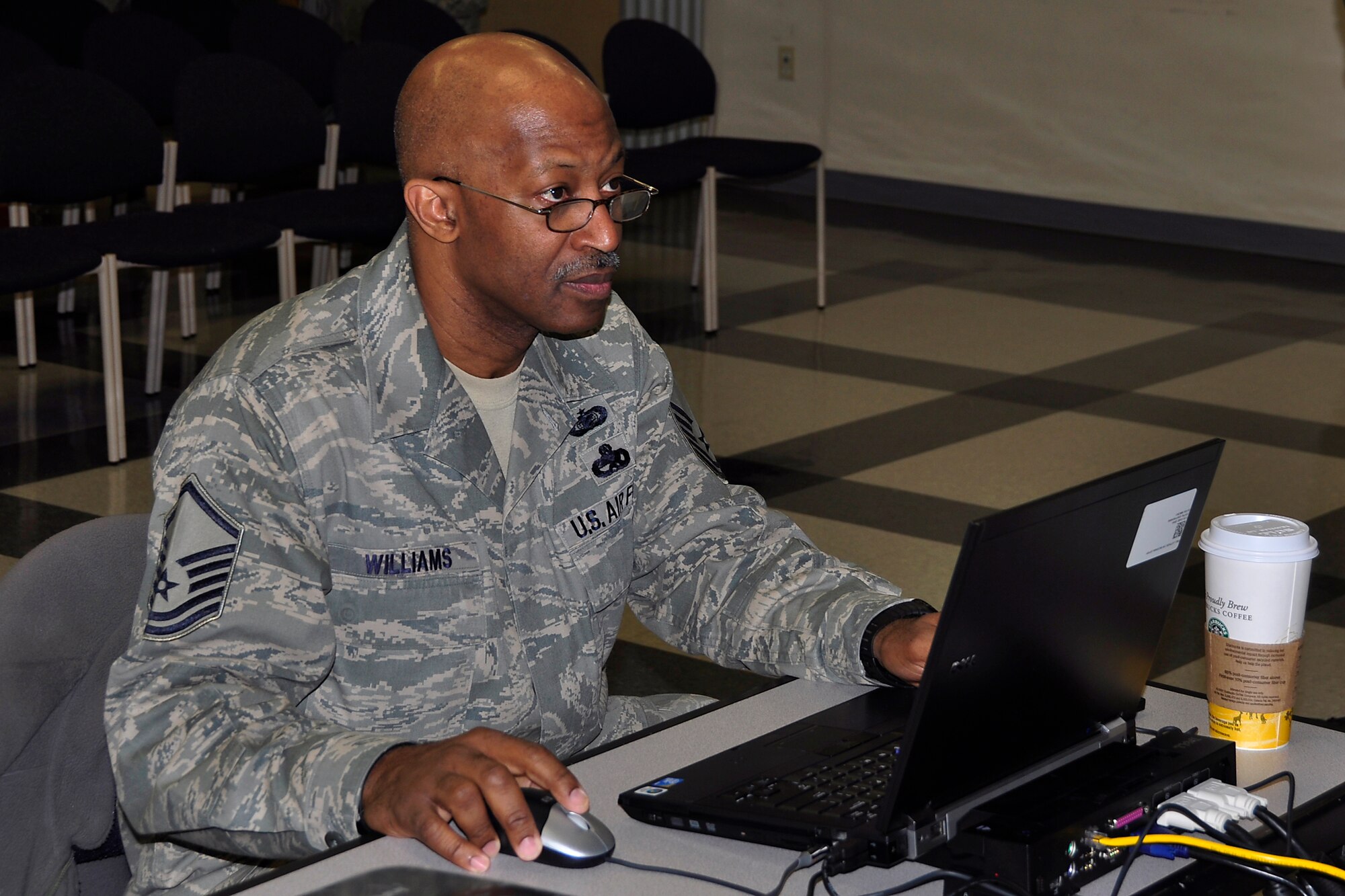 JOINT BASE MCGUIRE-DIX-LAKEHURST, N.J. -- Master Sgt. Derek Williams, a client support administrator with the 514th Air Mobility Wing, prepares computer equipment for a slideshow presentation prior to an assembly to discuss the wing’s recent inspections in an auditorium within the 514th Aeromedical Evacuation Squadron here March 22, 2011. The wing earned high marks in the unit compliance inspection, the logistics compliance assessment program and the aircraft standardization evaluation visit. (U.S. Air Force photo/Tech. Sgt. Shawn J. Jones)  
