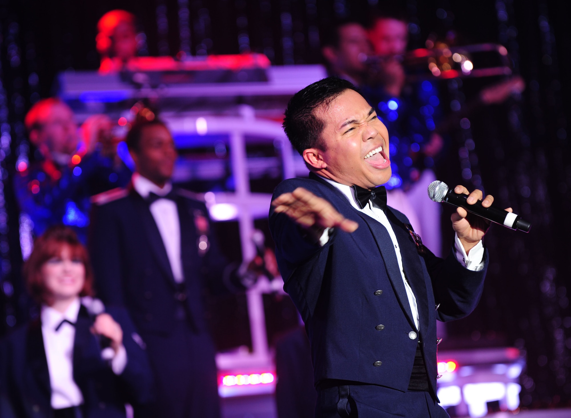 DAVIS-MONTHAN AIR FORCE BASE, Ariz. - Staff Sgt. Harron Elloso, vocalist for the Air Force’s Tops in Blue performance group, performs “Proud to be an American” an original song by Lee Greenwood during a recent show at the Tucson Convention Center in Tucson, Ariz., March 20. The 2011 show entitled “We Believe,” featured songs by various artists including Lady Gaga, the Black Eyed Peas and Journey. (U.S. Air Force photo/Airman 1st Class Jerilyn Quintanilla)