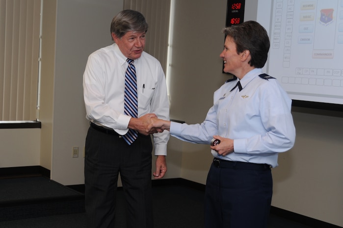 Mr. Michael Petersen receives a coin from Col. Martha Meeker during the Wing Stand-up on March 21, Joint Base Charleston, S.C.  Mr. Petersen was recognized for his excellent work as the Director of the Equal Opportunity Office.  (U.S. Air Force photo/ Staff Sgt. Nicole Mickle)