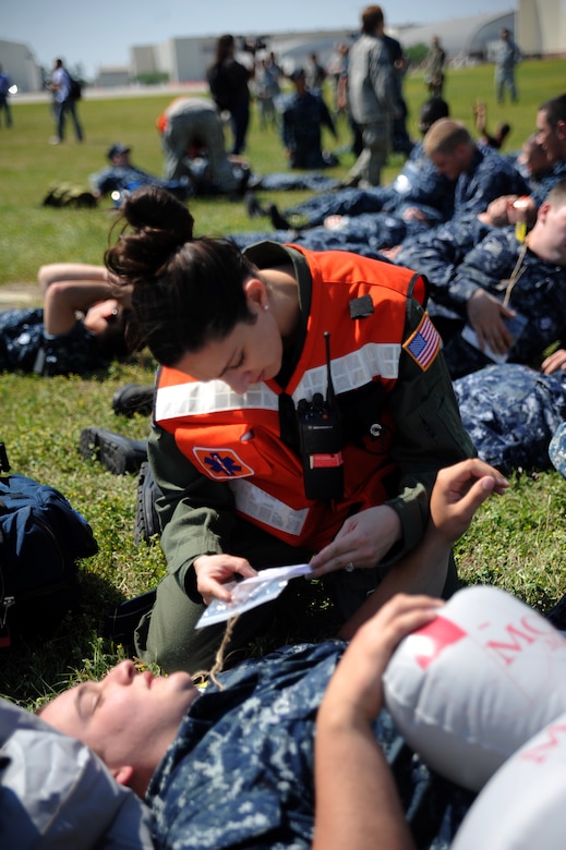 Capt. Melissa Ellis-Yarian examines a training card on a simulated victim describing the individuals symptoms during a Major Accident Response Exercise March 22, 2011 on Joint Base Charleston, S.C. The MARE is a necessary step to prepare all Joint Base Charleston members for the upcoming 2011 Air Expo. Captain Ellis-Yarian is a flight surgeon with the 628th Medical Group. (U.S. Air Force photo/Senior Airman Timothy Taylor)