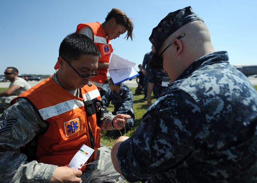 Tech. Sgt. Chun Fong evaluates a simulated victim during a Major Accident Response Exercise March 22, 2011 on Joint Base Charleston, S.C. The MARE is a necessary step to prepare all Joint Base Charleston members for the upcoming 2011 Air Expo. Sergeant Fong is an Independent Duty Medical Technician with the 628th Medical Group. (U.S. Air Force photo/Senior Airman Timothy Taylor) 