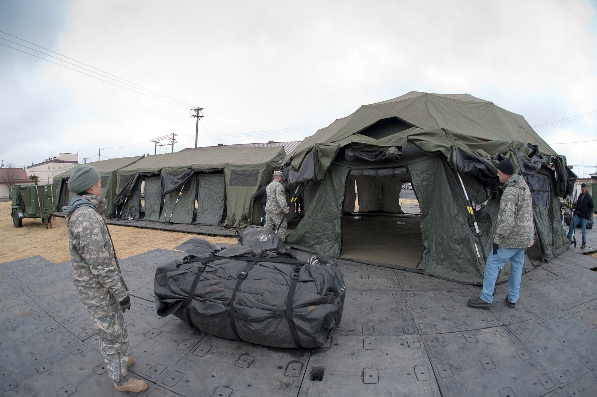 Pacific Command personnel build tents March 22, 2011, at Yokota Air Base, Japan. The tents will provide additional workspace for personnel deploying to Yokota AB in support of Operation Tomodachi. (U.S. Air Force photo/Osakabe Yasuo)