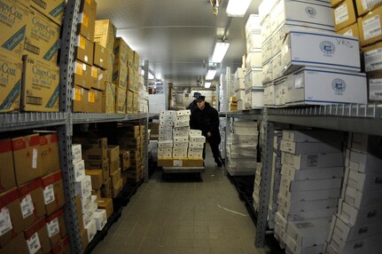 Surrounded by hundreds of frozen boxes in a 20-degree walk-in freezer, Culinary Specialist 2nd Class David Haeffner stacks frozen foods during a store’s on-load at the Joint Base Charleston-Weapons Station Galley, Mar. 17. 