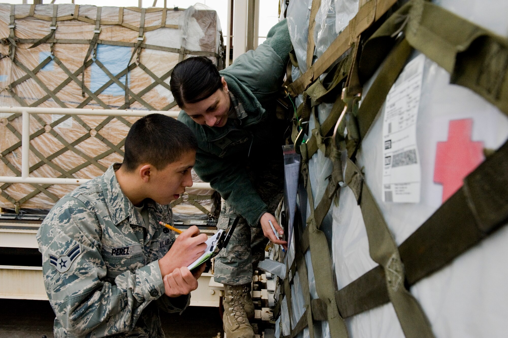 YOKOTA AIR BASE, Japan -- Airman 1st Class Isaac Perez, 374th Maintenance Squadron, and Senior Airman Mary Ringley, 374th Logistics Readiness Squadron (LRS), keeps track of inbound cargo for Operation Tomodachi here March 23. The 374th LRS has been working with 730th Air Mobility Squadron to store and deliver en-route cargo to aircraft and vehicles in support of humanitarian assistance. The cargo that the 730th AMS and 374th LRS processed includes water, food, medical supplies and other basic needs. (U.S. Air Force photo/Staff Sgt. Jonathan Steffen)