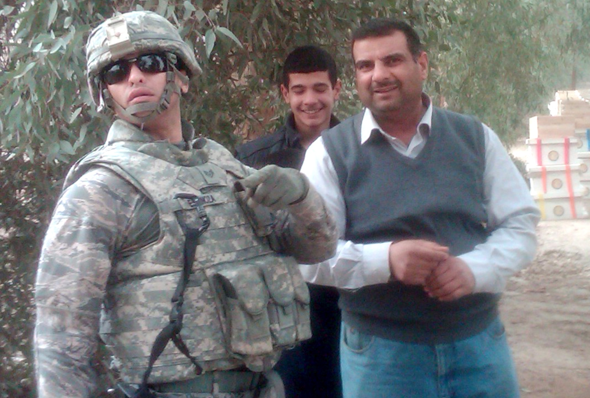 Staff Sgt.Walberto Espinoza poses for a photo with locals during a mission Feb. 20, 2011, in Karbala, Iraq. (Courtesy Photo) 
