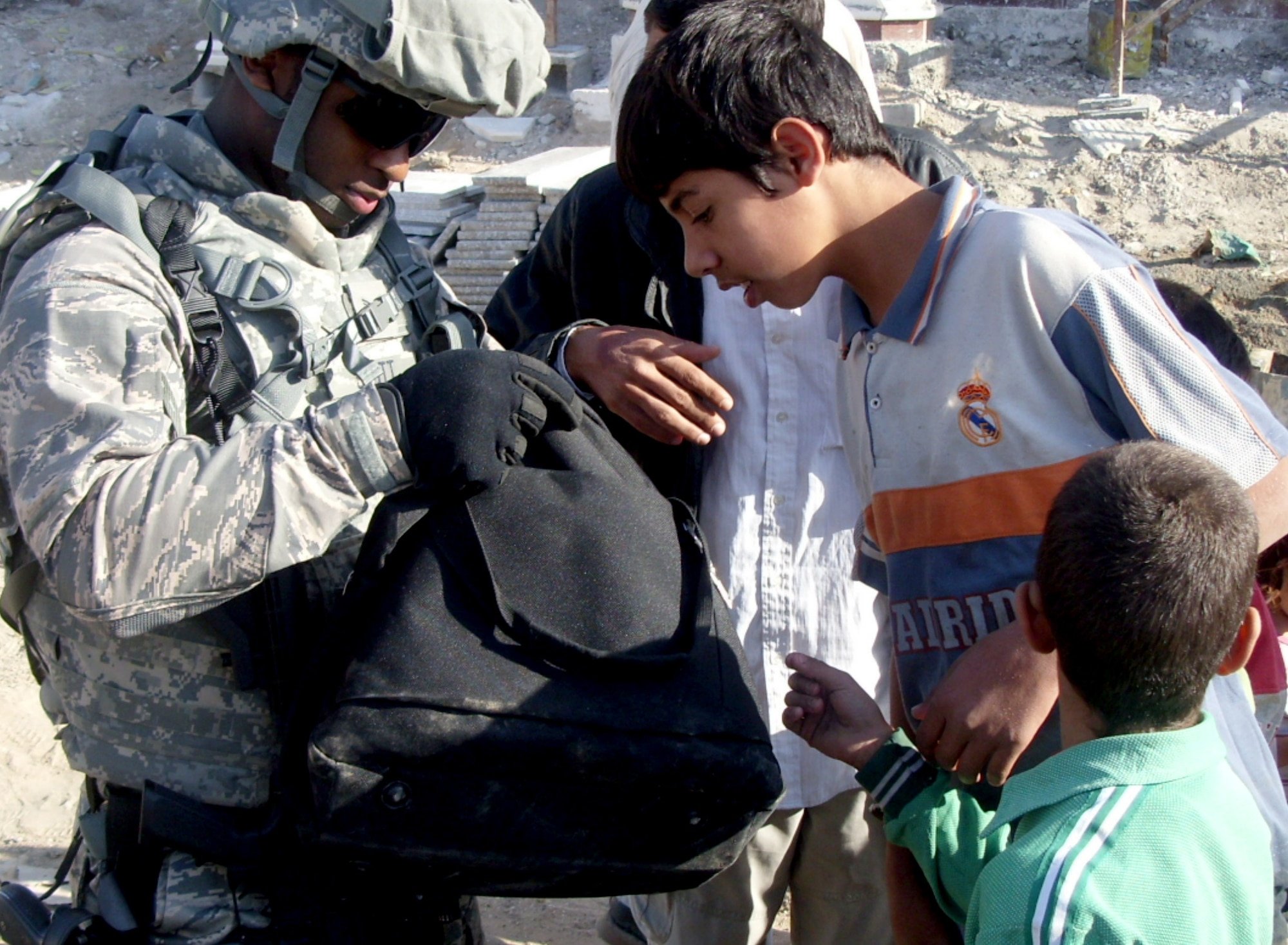 Staff Sgt. Kevin Scott Jr. hands kids toys and shoes during a mission Nov. 30, 2010, in Karbala, Iraq. (Courtesy Photo) 
