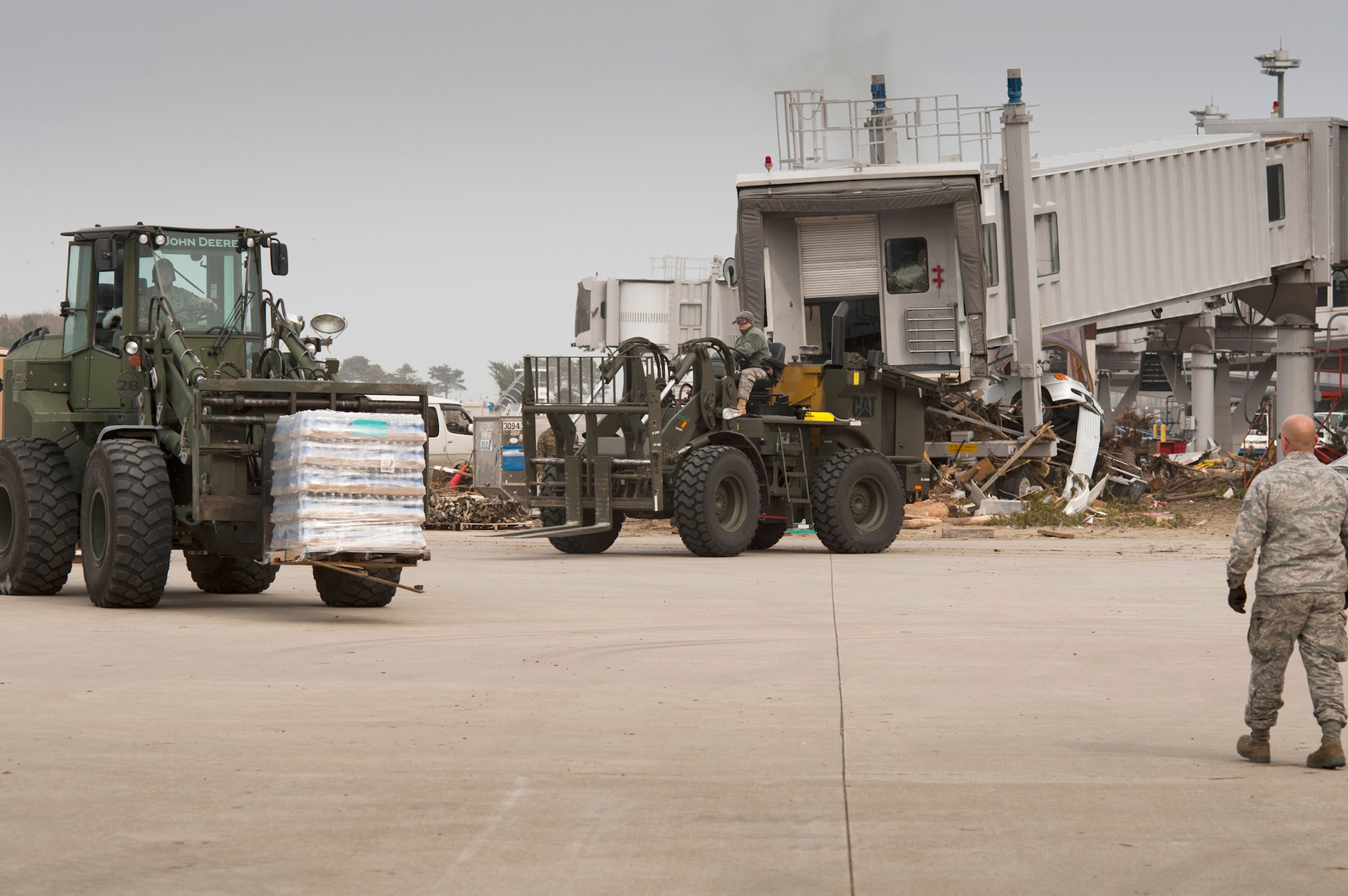 Members of the 353rd Special Operations Group drive forklifts carrying pallets of freshwater to be loaded onto Japan Ground Self-Defense Force trucks March 20, 2011, at Sendai Airport, Japan. Airmen from the 320th Special Tactics Squadron manage the airfield with the help of the 353rd SOG, Marines, JGSDF and other Japanese agencies. Sendai Airport has become a main hub for bringing humanitarian aid to those affected by the March 11 earthquake and tsunami. (U.S. Air Force photo/Staff Sgt. Samuel Morse) 