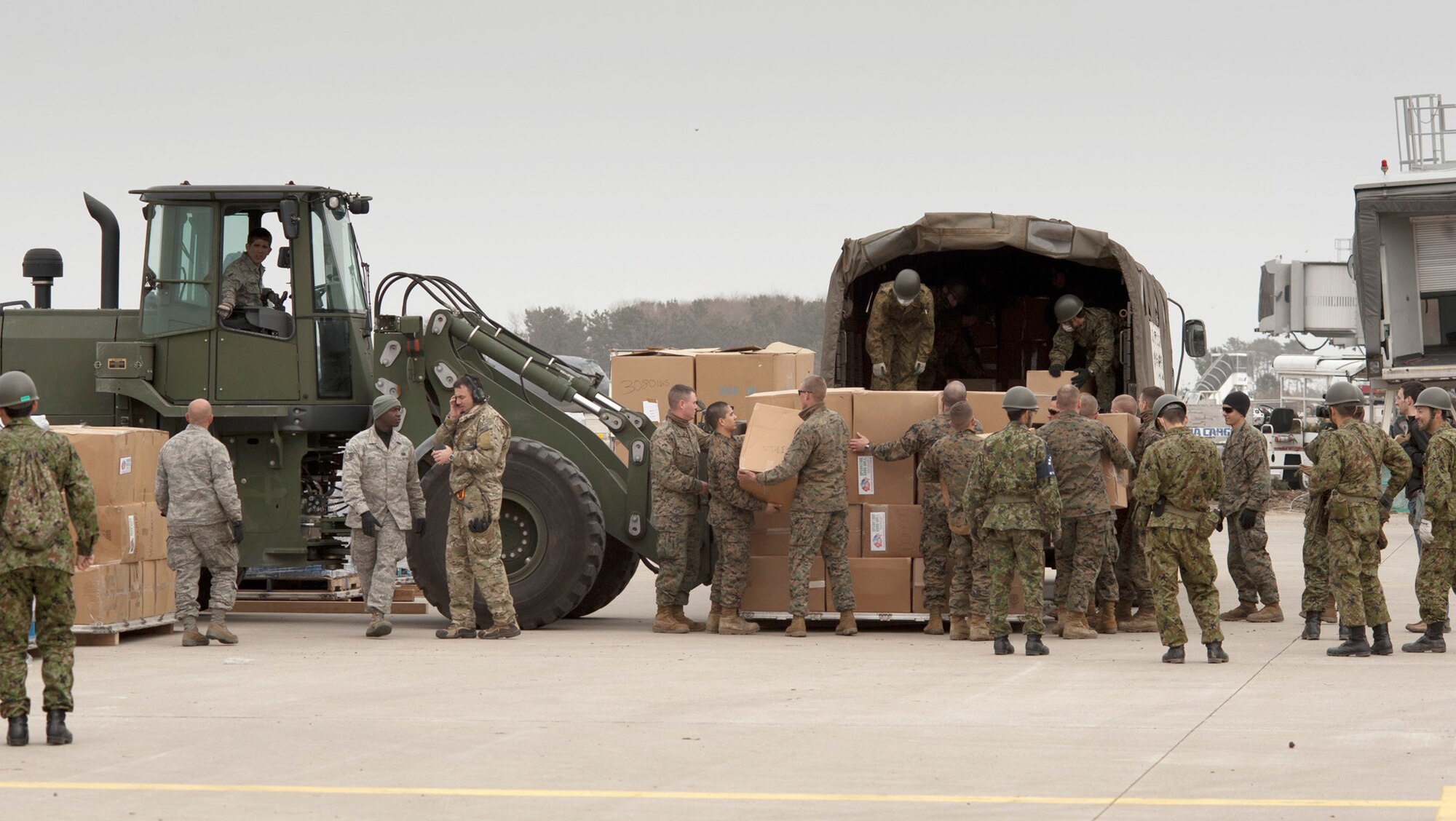 Airmen, Marines and Japan Ground Self-Defense Force soldiers load cargo onto a JGSDF truck March 20, 2011, at Sendai Airport, Japan. Since the re-opening of Sendai Airport March 16, humantitarian aid supporting Operation Tomodachi has been able to be airlifted in more quickly and directly. (U.S. Air Force photo/Staff Sgt. Samuel Morse)