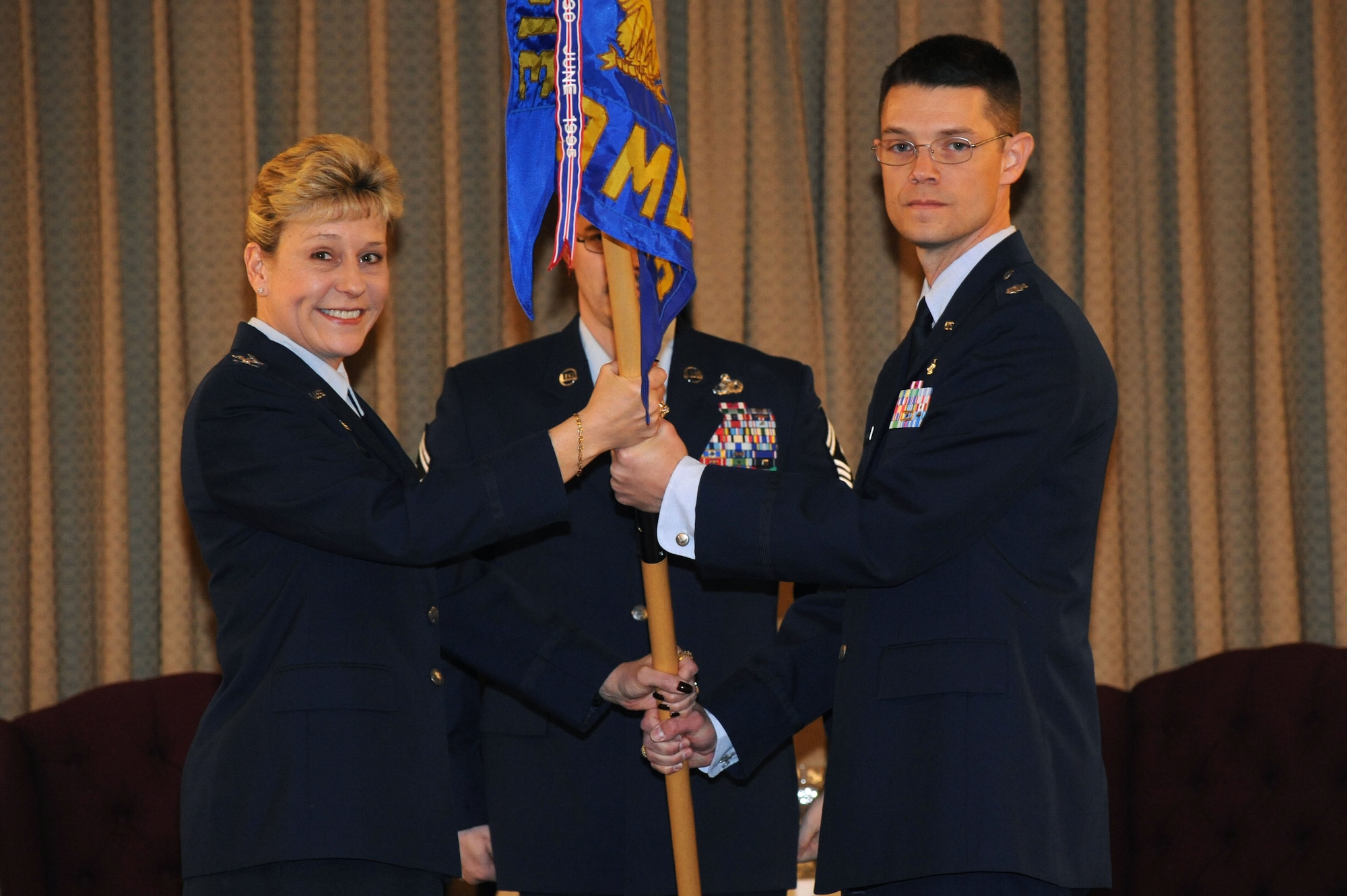 Lt. Col. Jason Buckner receives the 319th Medical Support Squadron guideon from Col. Jane Denton, 319th Medical Support Squadron commander during an assumption of command ceremony March 22, 2011. (U.S. Air Force photo by Airman 1st Class Amber Bennett)