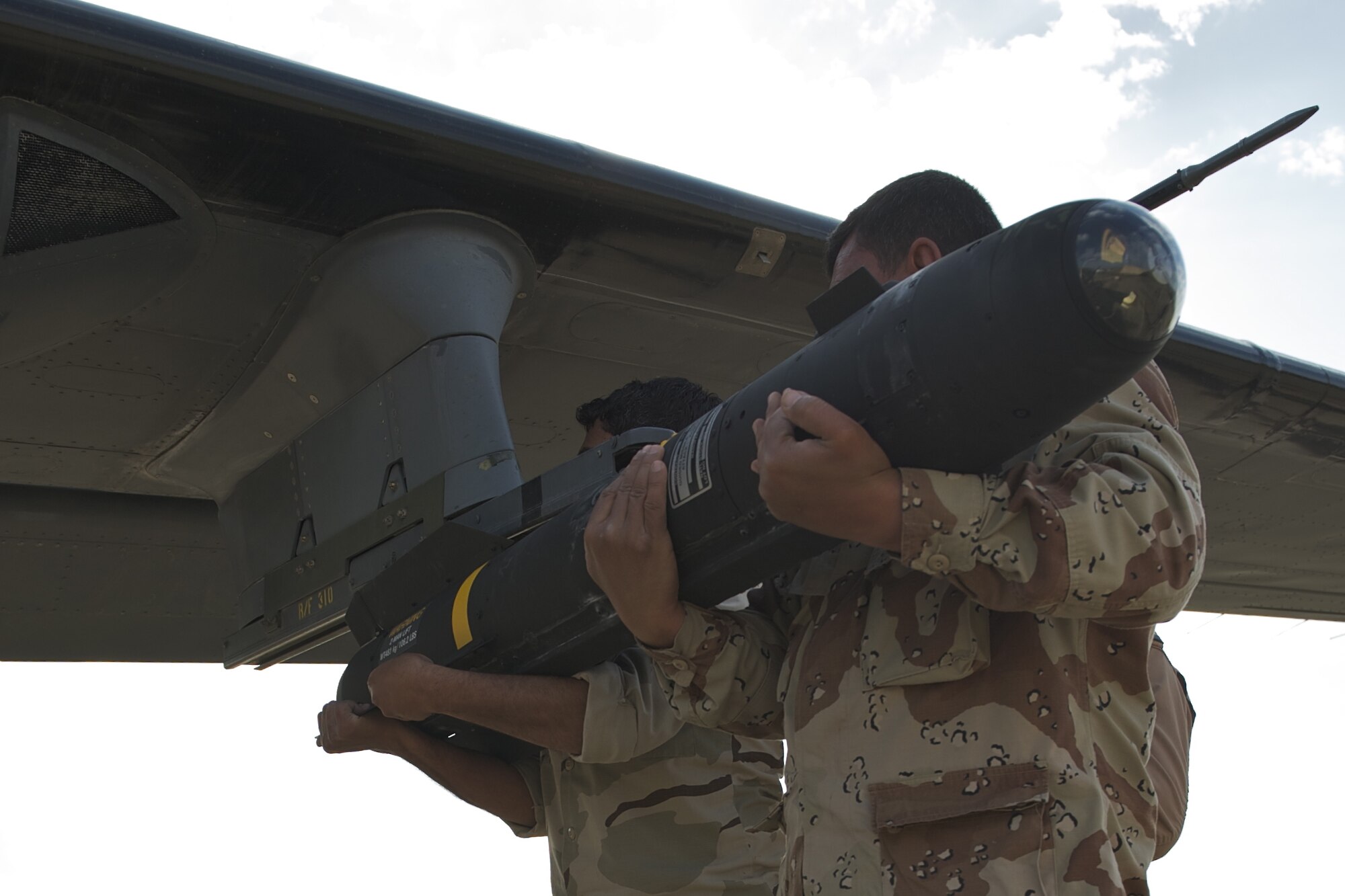 KIRKUK, Iraq – Iraqi airmen load an AGM-114 Hellfire missile onto an AC-208 Cessna Caravan for an operational exercise March 23. Iraqi air force pilots hit a specific ground target with guidance and direction from Iraqi special operations forces forward air controllers on the Aziziyah Training Range, south of Baghdad. (U.S. Air Force photo by Staff. Sgt. Levi Riendeau)