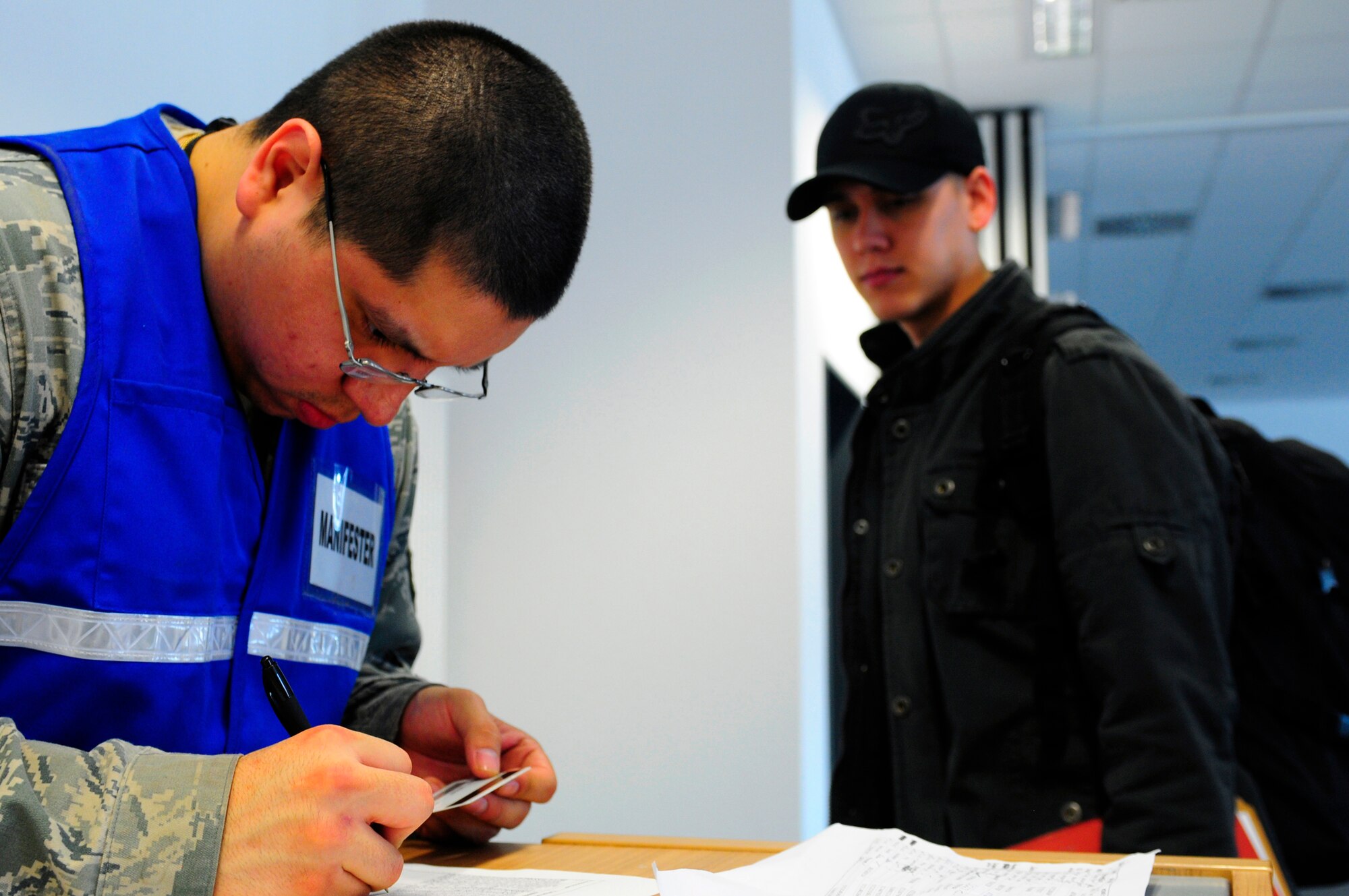 U.S. Air Force Senior Airman Maguina Frank, 86th Logistics Readiness Squadron, processes Airman 1st Class Randall Watson, 86th Civil Engineer Squadron, in preparation for a deployment in support of Joint Task Force Odyssey Dawn, Ramstein Air Base, Germany, March 21, 2011. The U.S. Africa Command task force was established to provide operational and tactical command and control of U.S. military forces supporting the international response to the unrest in Libya and enforcement of United Nations Security council Resolution 1973. UNSCR 1873 authorizes all necessary measures to protect civilians in Libya under threat of attack by Qadhafi regime forces. JTF Odyssey Dawn is commanded by U.S. Navy Admiral Samuel J. Locklear, III.  (U.S. Air Force Photo by Airman 1st Class Brea Miller)