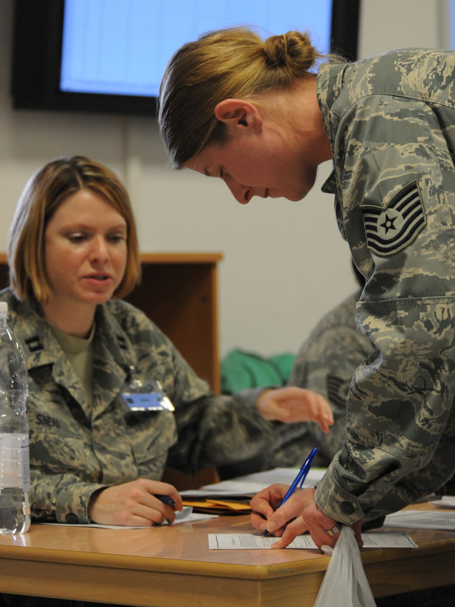 SPANGDAHLEM AIR BASE, Germany – A 52nd Component Maintenance Squadron tech. sgt. signs paperwork as she processes through the personnel deployment function line here before leaving in support of Operation Odyssey Dawn March 20. Joint Task Force Odyssey Dawn is the U.S. Africa Command task force established to provide operational and tactical command and control of U.S. military forces supporting the international response to the unrest in Libya and enforcement of United Nations Security Council Resolution (UNSCR) 1973. UNSCR 1973 authorizes all necessary measures to protect civilians in Libya under threat of attack by Qadhafi regime forces.  JTF Odyssey Dawn is commanded by U.S. Navy Admiral Samuel J. Locklear, III. (U.S. Air Force photo/Staff Sgt. Benjamin Wilson)